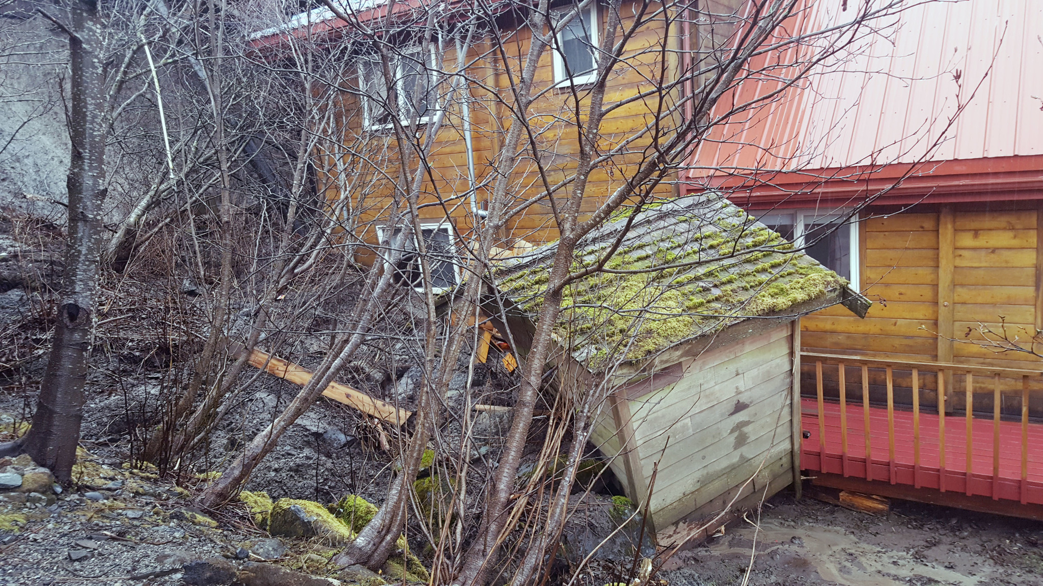 A mudslide caused when a retaining wall failed Wednesday pushed a shed down the hill and piled mud and debris up to the window of a residence in the 2500 block of Douglas Highway. (Liz Kellar | Juneau Empire)