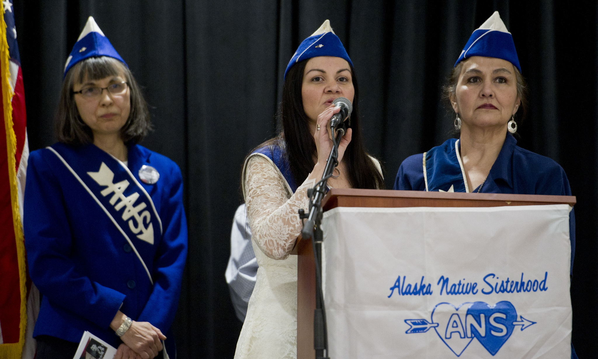 Alaska Native Sisterhood Camp 2 President Rhonda Butler, center, flanked by ANS Camp 2 Vice President Ann Chilton, right, and ANS Camp 70 Sergeant at Arms Lillian Petershoare, welcomes about 150 people to the Elizabeth Peratrovich Day ceremony in the Elizabeth Peratrovich Hall on Thursday. (Michael Penn | Juneau Empire)
