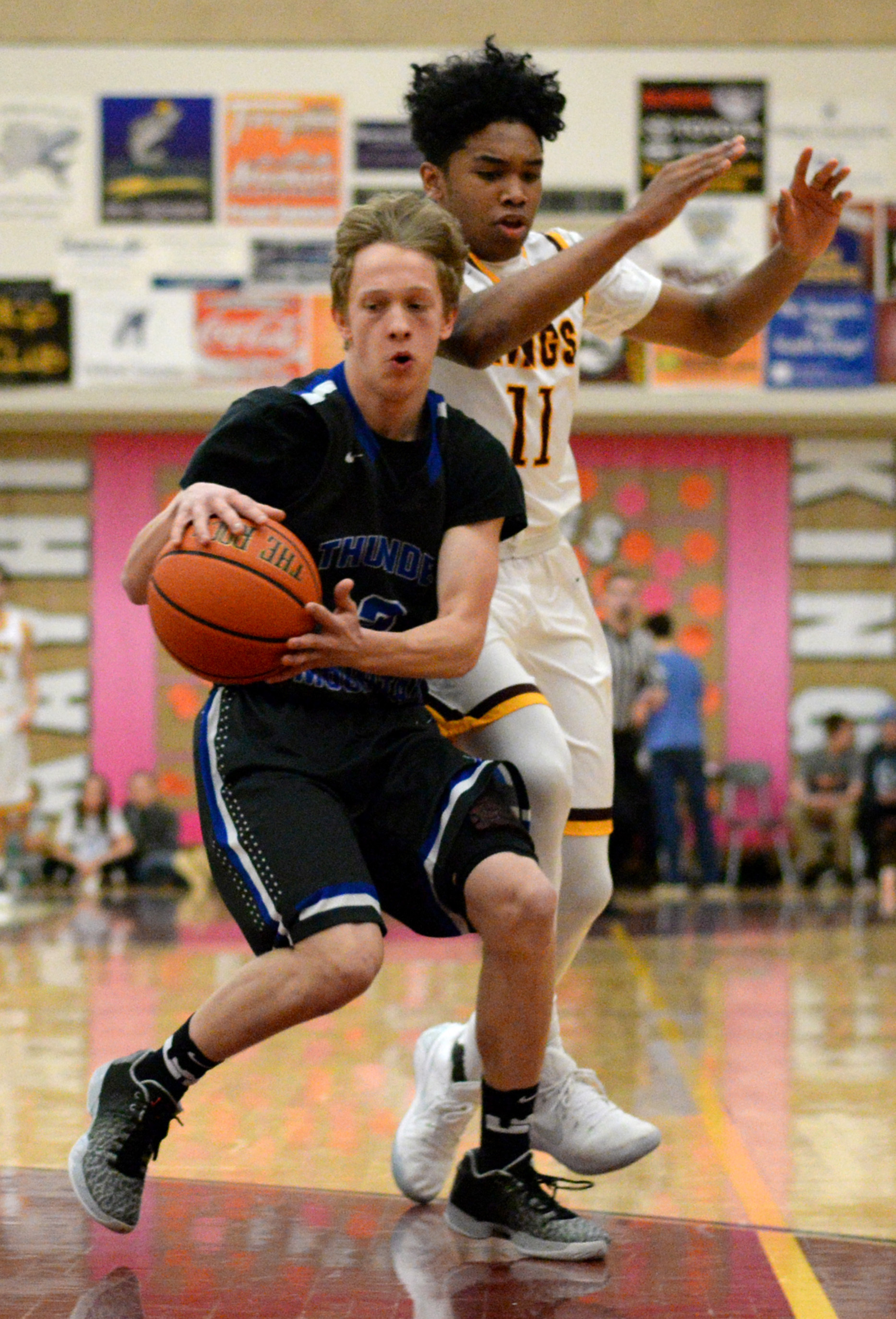 Thunder Mountain senior Zebadiah Storie (2) makes a move around Ketchikan High School freshman Chris Lee (11) on Saturday, Feb. 25, 2017, during the Falcons’ 68-67 loss to the Kings in the Clarke Cochrane Gym. (Taylor Balkom | Ketchikan Daily News)