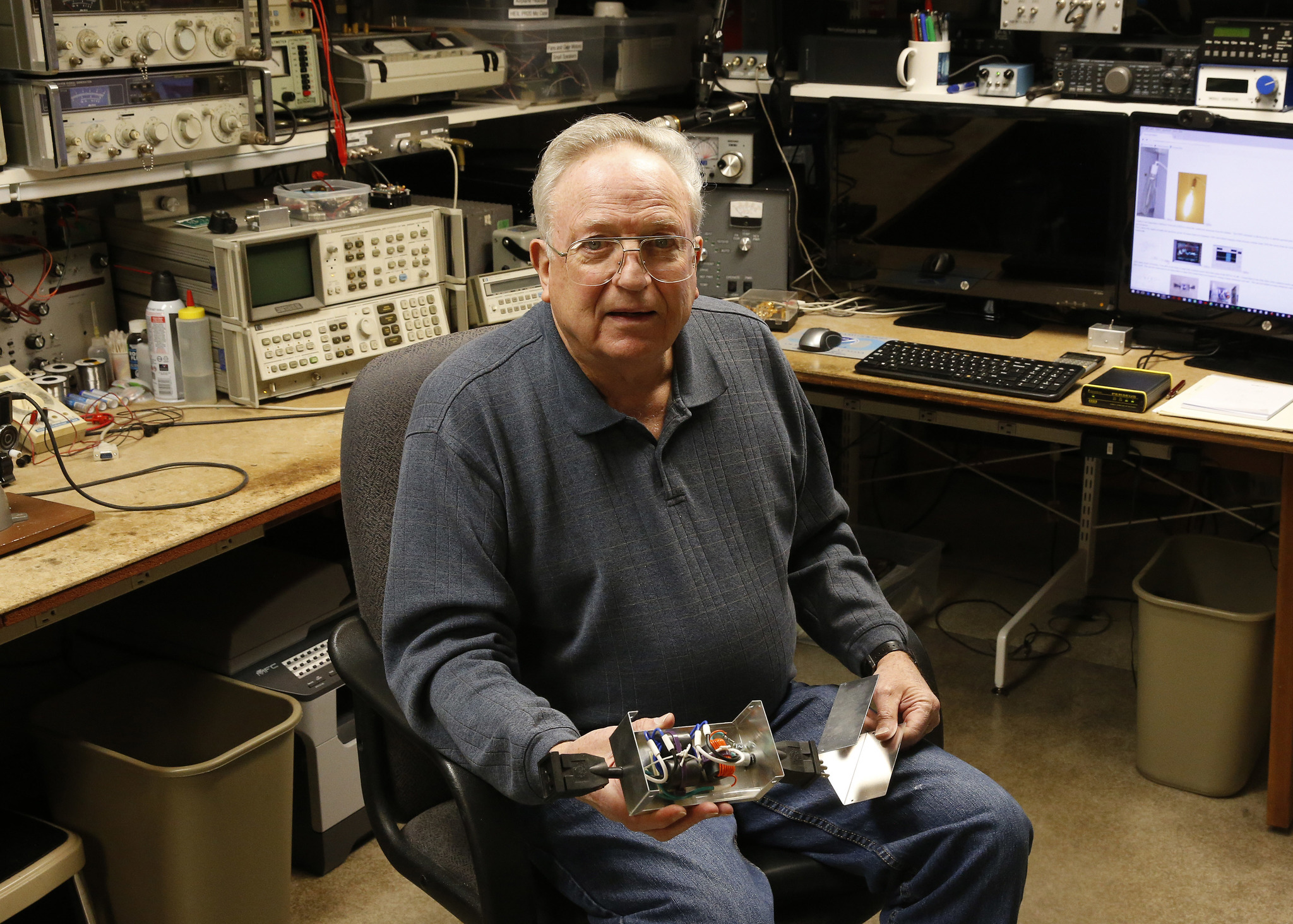In this Feb. 21 photo, lifelong ham radio operator and expert tinkerer Tom Thompson holds a radio wave filter he invented inside his basement home office in Boulder, Colorado. (Brennan Linsley | The Associated Press)