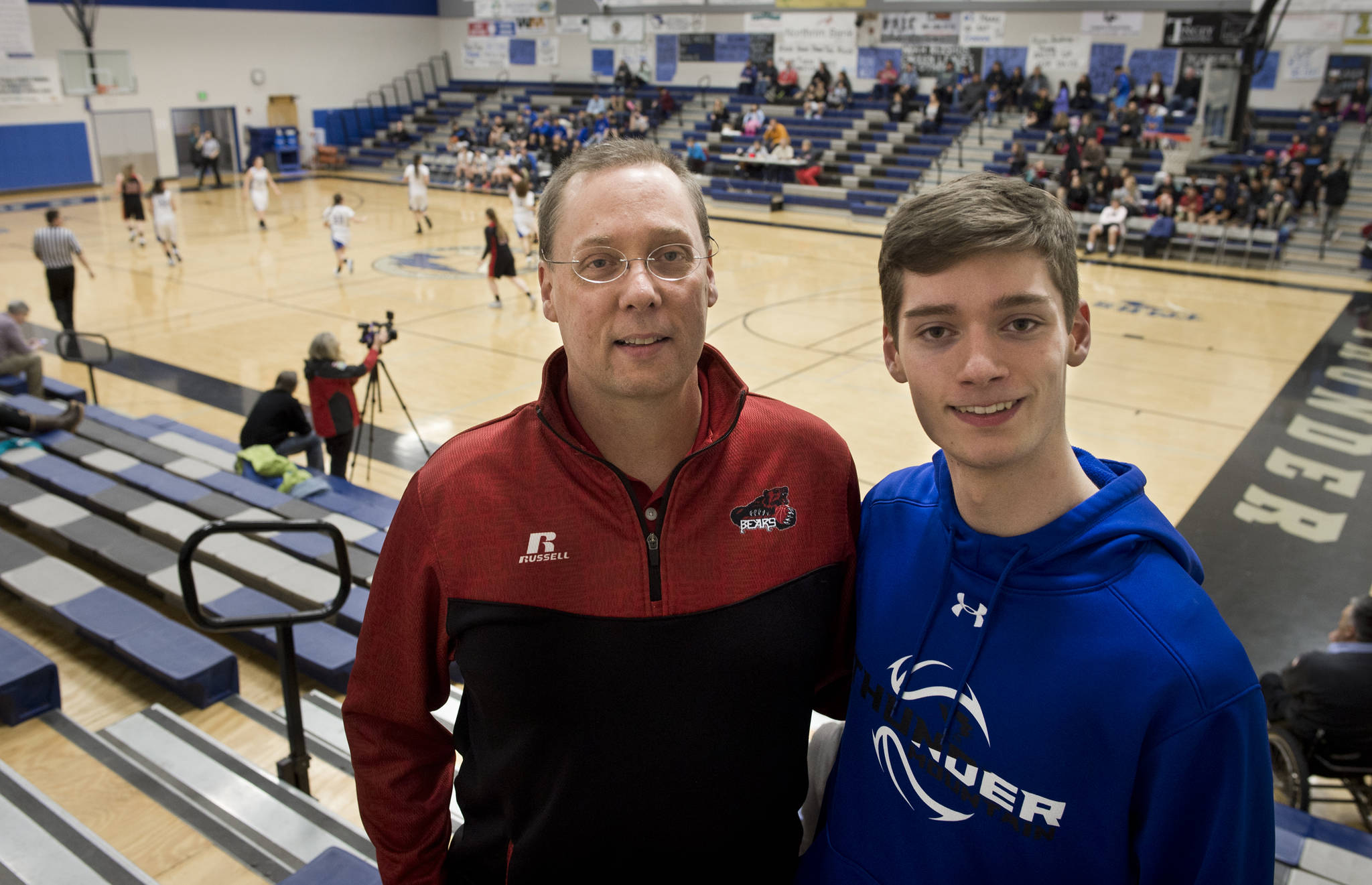 John Sleppy and his son, Justin, 18, photographed at the Thunder Mountain High School gymnasium on Feb. 1. John is an assistant coach for the Juneau-Douglas High School boys varsity team and Justin is a student team manager for the Thunder Mountain High School boys varsity team. (Michael Penn | Juneau Empire)