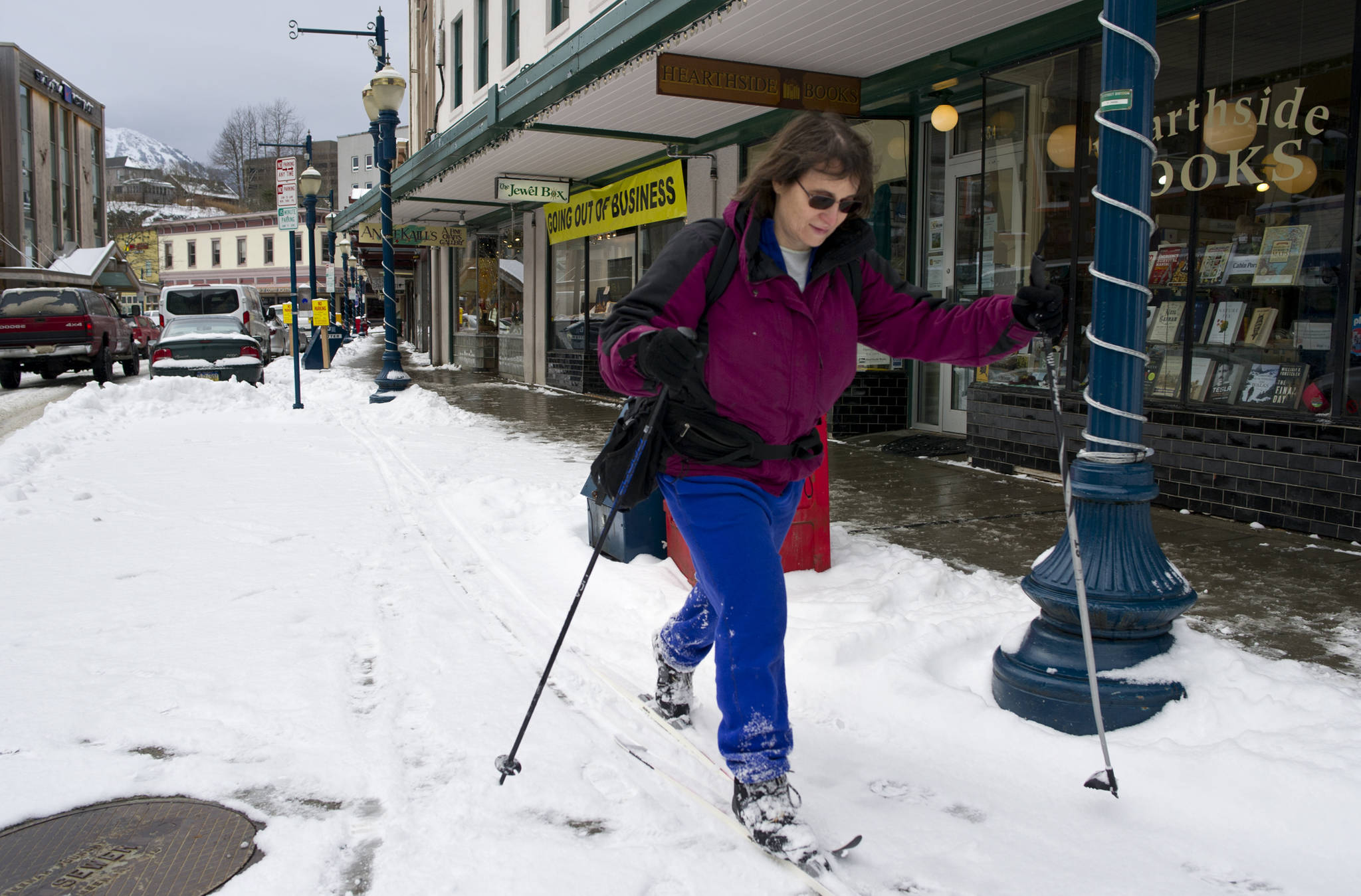 Jodie Pessolano takes advantage of recent snow to ski along Front Street on Thursday. (Michael Penn | Juneau Empire)