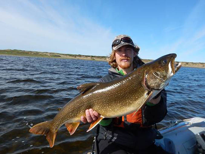 Kurt Heim shows a lake trout he caught in the Fish Creek watershed on the Arctic Coastal Plain. (Photo by Lydia Smith)