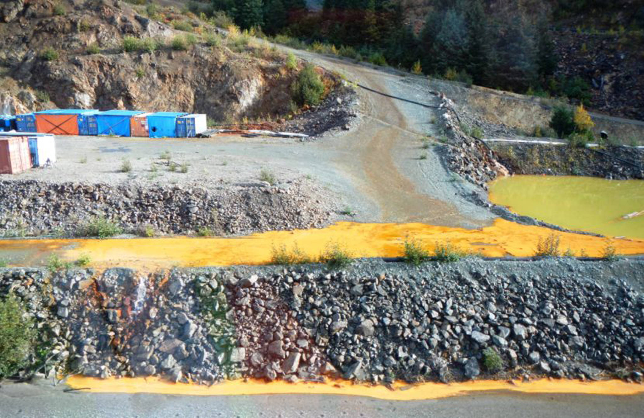 The Tulsequah Chief Mine is seen on Sept. 26, 2016. The yellow water is Acidic Mine Drainage from shuttered mine adits. It drains into an “exfiltration pond,” pictured, which overflows into the Tulsequah River. (Courtesy Photo)