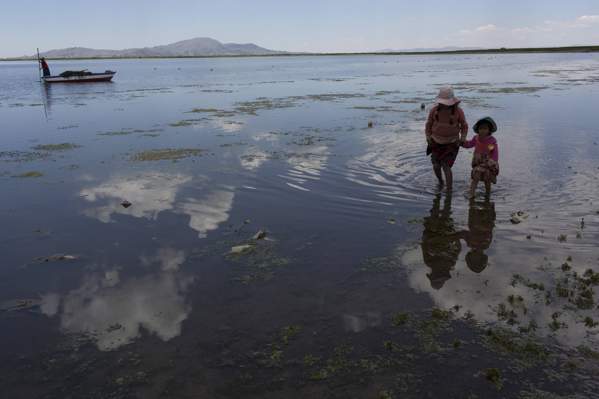 In this Feb. 2 photo, cousins from the Avila family search for discarded toys on the shores of Lake Titicaca, in Coata in the Puno region of Peru.The shores of South America’s largest lake are littered with dead frogs, discarded paint buckets and bags of soggy trash. Less visible threats lurk in the water itself: highly toxic levels of lead and mercury. (Rodrigo Abd | The Associated Press)
