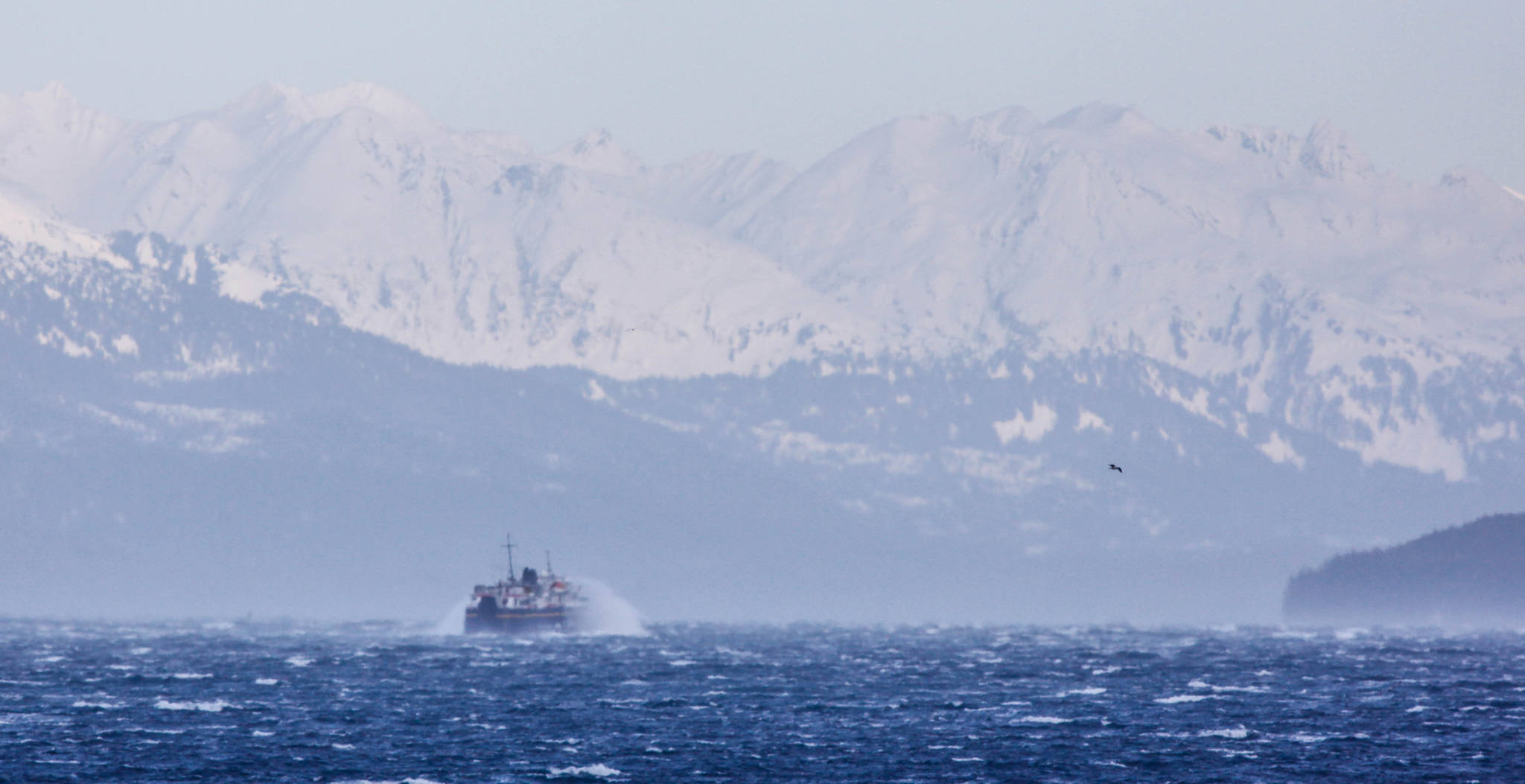 The ferry LeConte passes by Shelter Island with the snow capped Chilkat Mountains are in the background. It has been cold and very windy in Lynn Canal. (Photo by Jay Beedle)