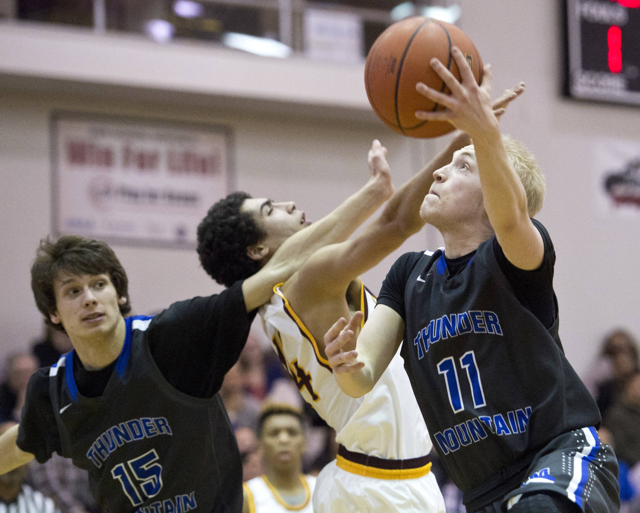 Thunder Mountain&rsquo;s Chase Saviers, right, as teammate Noah Reishus-O&rsquo;Brien, right, blocks out Ketchikan&rsquo;s Shakim Bauer during the 4A Regional V Basketball Tournament at JDHS on Wednesday. Ketchikan won 65-44. (Michael Penn | Juneau Empire)