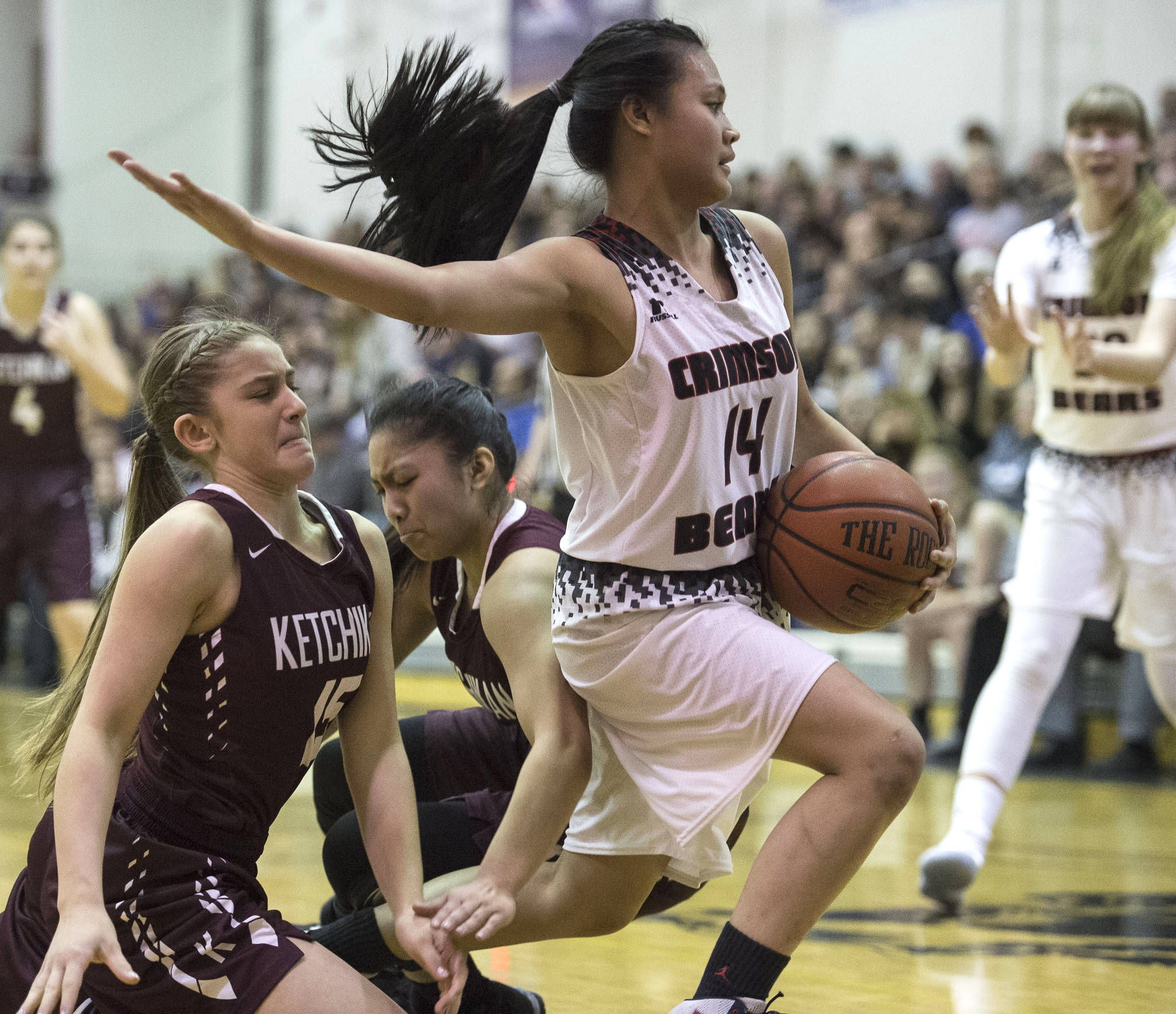 Juneau-Douglas Alyxn Bohulano, right, breaks away from Ketchikan’s Madison Rose, left, and AJ Dela Cruz during the Region V Basketball finals at JDHS on Friday. Ketchikan won 41-39 to force a playoff game on Saturday. (Michael Penn | Juneau Empire)