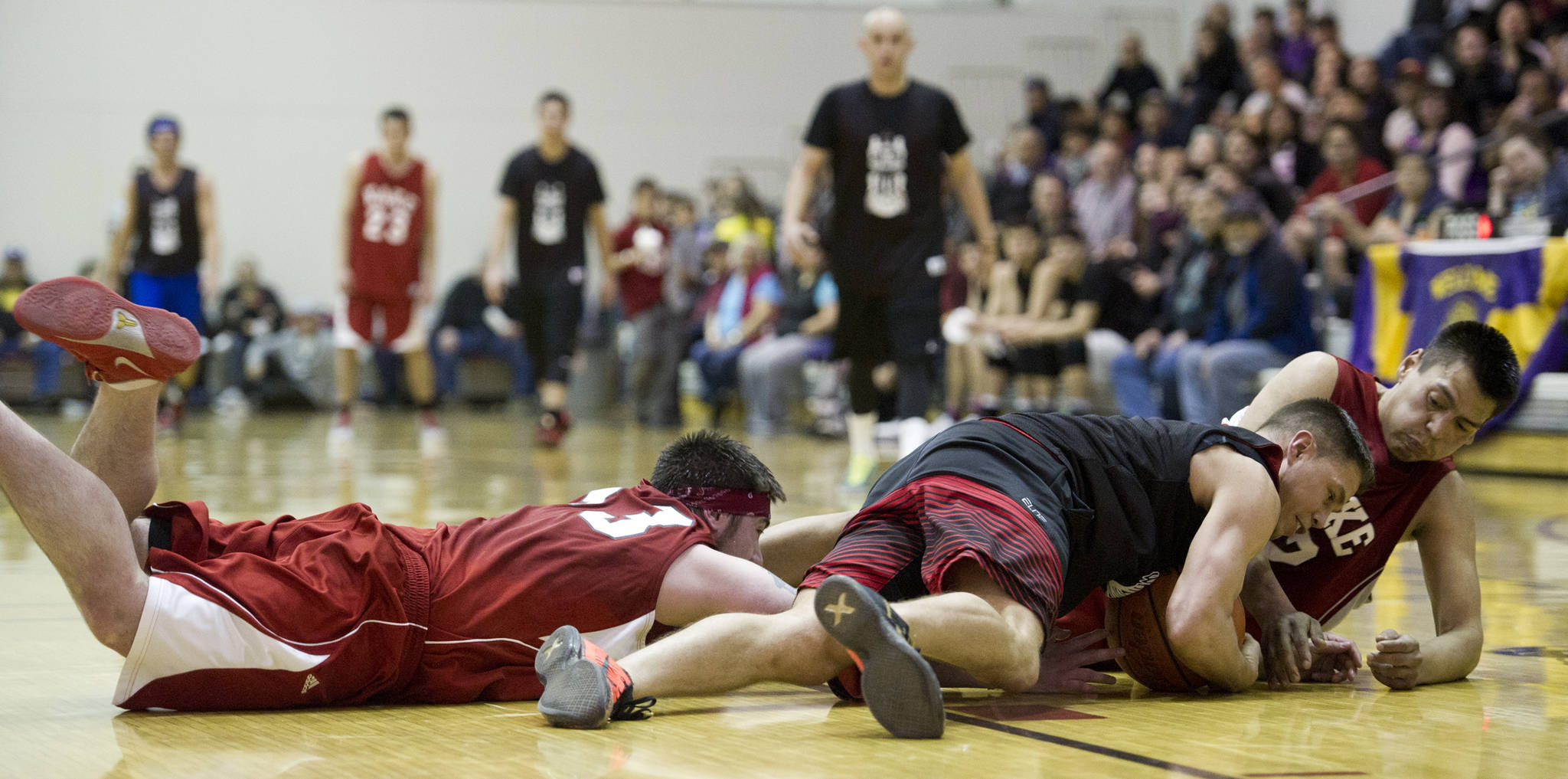 Hydaburg’s Vinny Edenshaw, center, wrestles a loose ball away from Kake’s Lance Doake, right, and Shea Jackson during their B bracket game in the 2016 Juneau Lions Club 70th Gold Medal Basketball Tournament at Juneau-Douglas High School on March 24, 2016. Hydaburg won 76-72. (Michael Penn | Juneau Empire File)