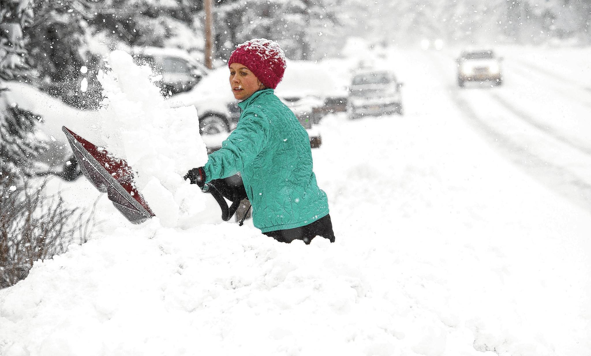 Dawn Jouppi shovels snow in front of her North Douglas Highway house on Monday. Michael Penn | Juneau Empire