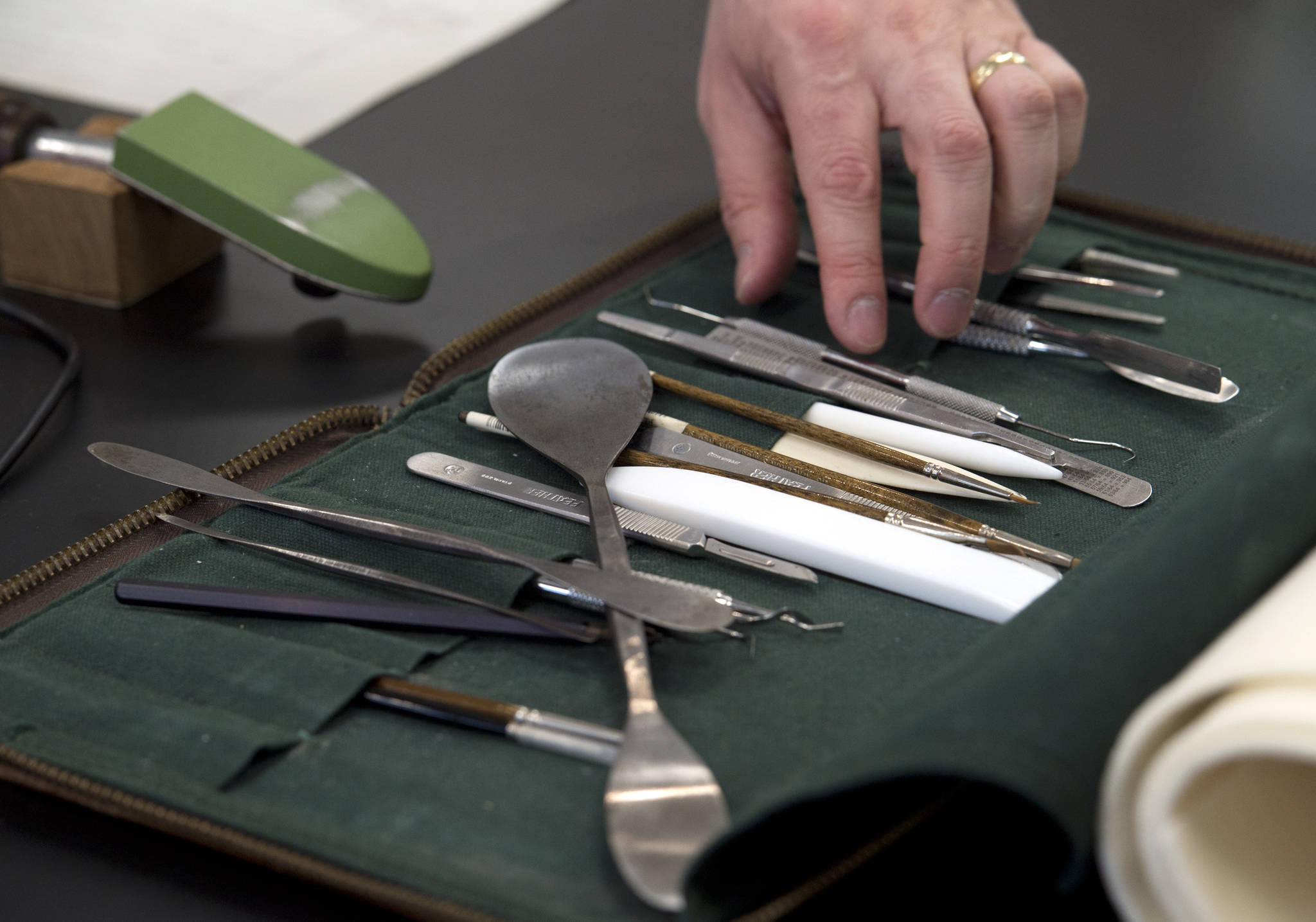 Seth Irwin, a paper conservator from Boston, picks through his tools while working at the Alaska State Museum on Sesquicentennial documents that will go on display later this year. (Michael Penn | Juneau Empire)