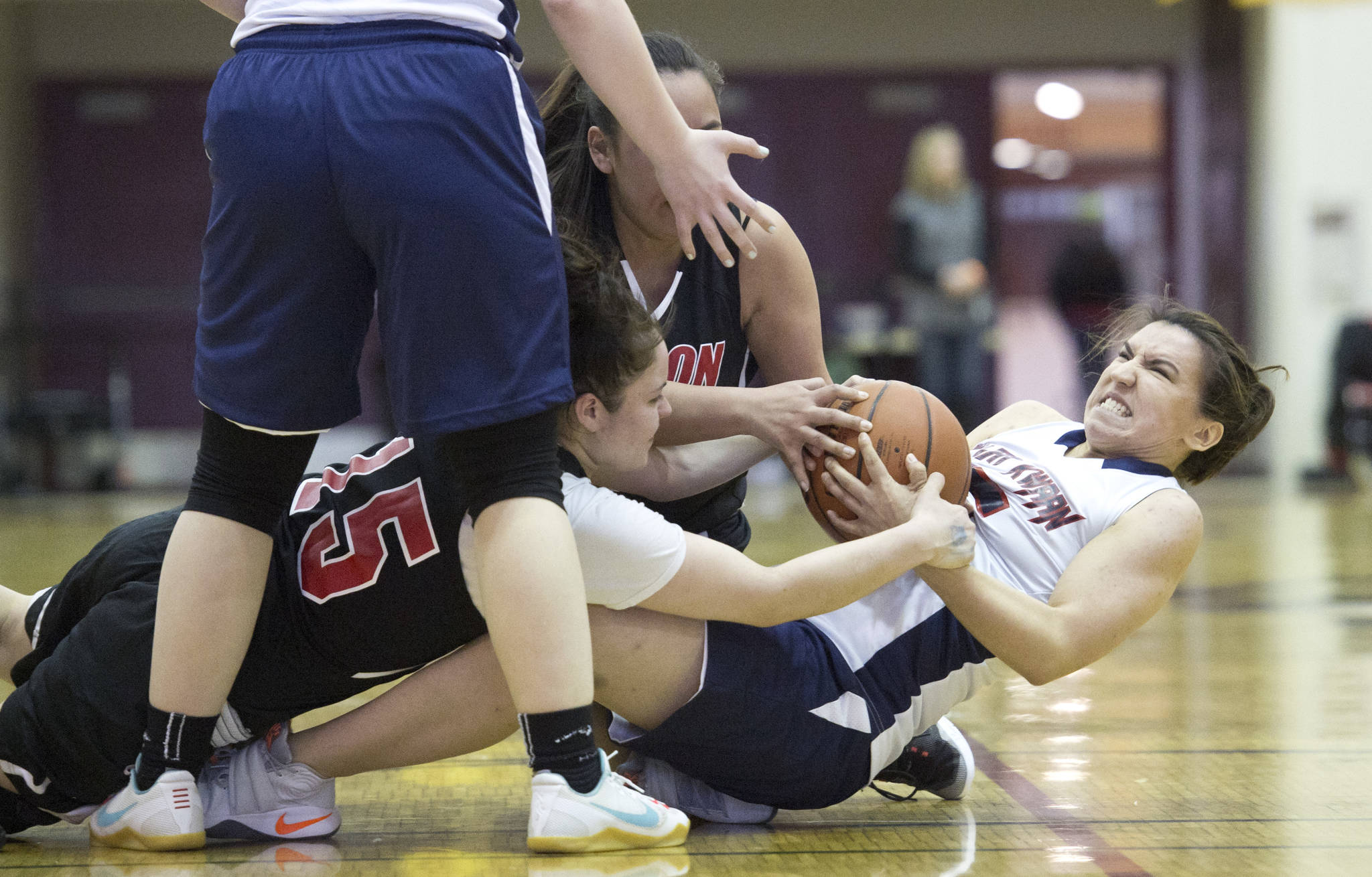Yakutat’s Lorena Williams, right, wrestles with Angoon’s Roxann Braley, left, and Rosanna See for the ball during the Women’s Bracket game in the Lions Club’s Gold Medal Basketball Tournament at Juneau-Douglas High School on Tuesday. Yakutat won 61-41. (Michael Penn | Juneau Empire)