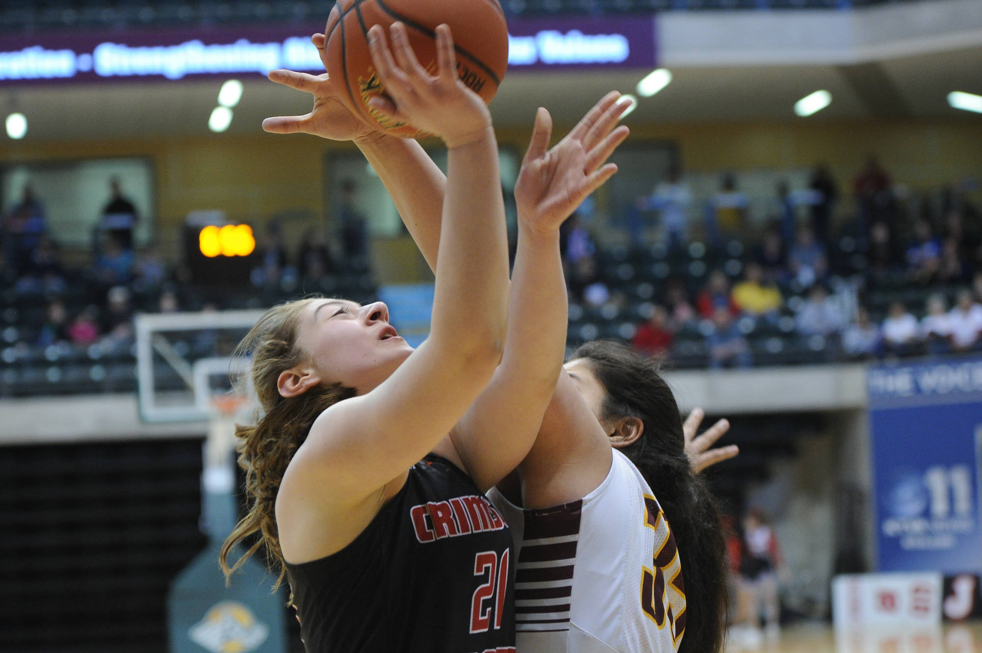 Juneau&rsquo;s Cazzie Dzinich puts a shot up against the defense of Dimond&rsquo;s Alissa Pili. (Michael Dinneen | For the Juneau Empire)