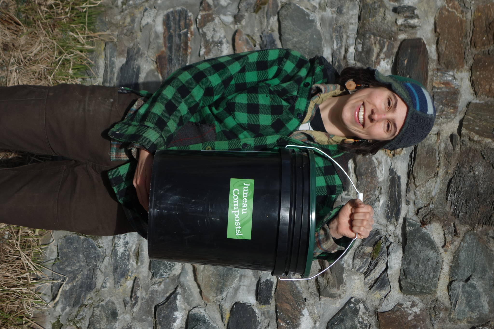 Lisa Daugherty, owner of Juneau Composts, picks up a filled bucket from a customer on a Friday morning. Photo by Clara Miller of Capital City Weekly.