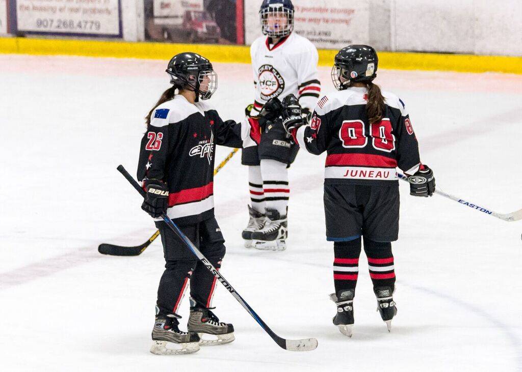 PHOTOS COURTESY OF KIM HORT Nikki Lanhum, left, fist bumps Paige Adams during the Juneau Capitals game against Hockey Club Fairbanks on Friday at the Subway Sports Centre in Anchorage.