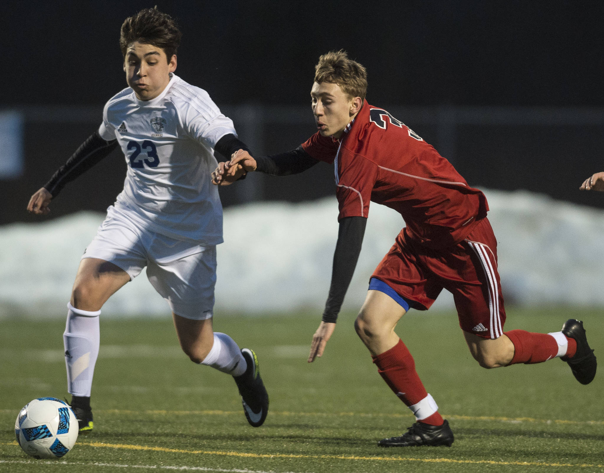 Thunder Mountain&rsquo;s Franco Vidal, left, races Juneau-Douglas&rsquo; Aidan Hopson to the ball during their first match of the season at TMHS on Friday, March 31, 2017. (Michael Penn | Juneau Empire)