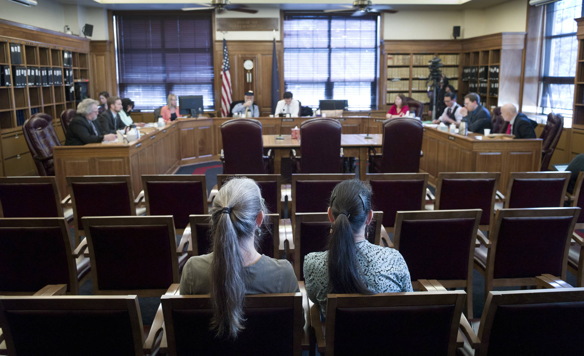 Luann McVey, left, and Laura Stats sit in the mostly vacant public seating area after giving their public testimony on SB 26 to the House Finance Committee at the Capitol on Monday, April 10, 2017. (Michael Penn | Juneau Empire)
