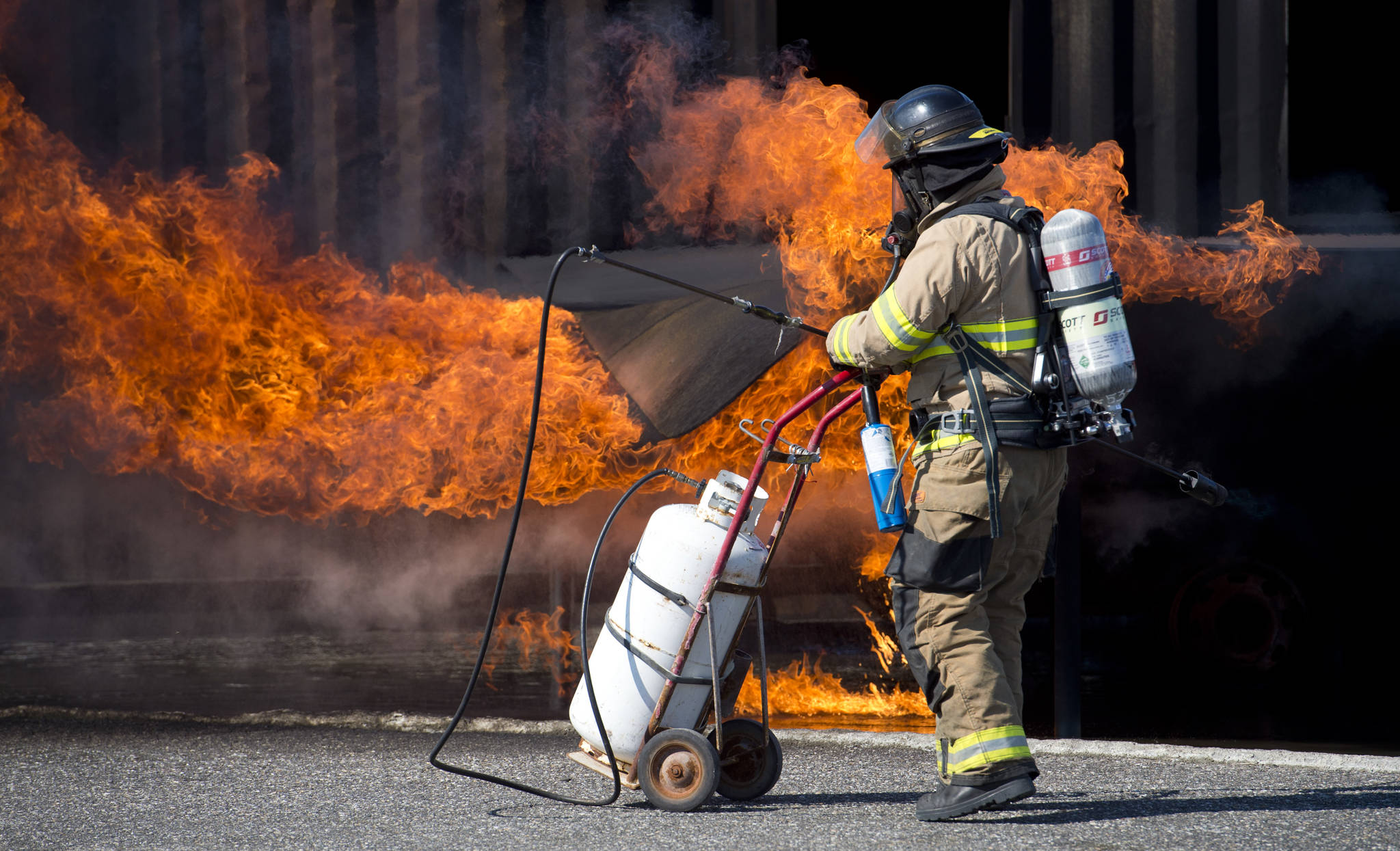 photos by michael penn | juneau empire Krista Telnes lights a training fire as Southeast firefighters update their airport rescue firefighting skills at the Hagevig Regional Fire Training Center on Thursday. See more photos on page A10.
