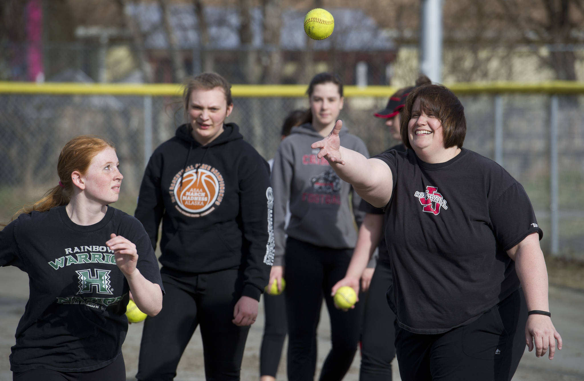 Juneau-Douglas High School girls varsity softball head coach Lexie Razor throws a ball for freshman Kamper Hart during a warmup drill during practice at Melvin Park on Tuesday, April 25, 2017. JDHS plays Ketchikan this weekend. (Michael Penn | Juneau Empire)