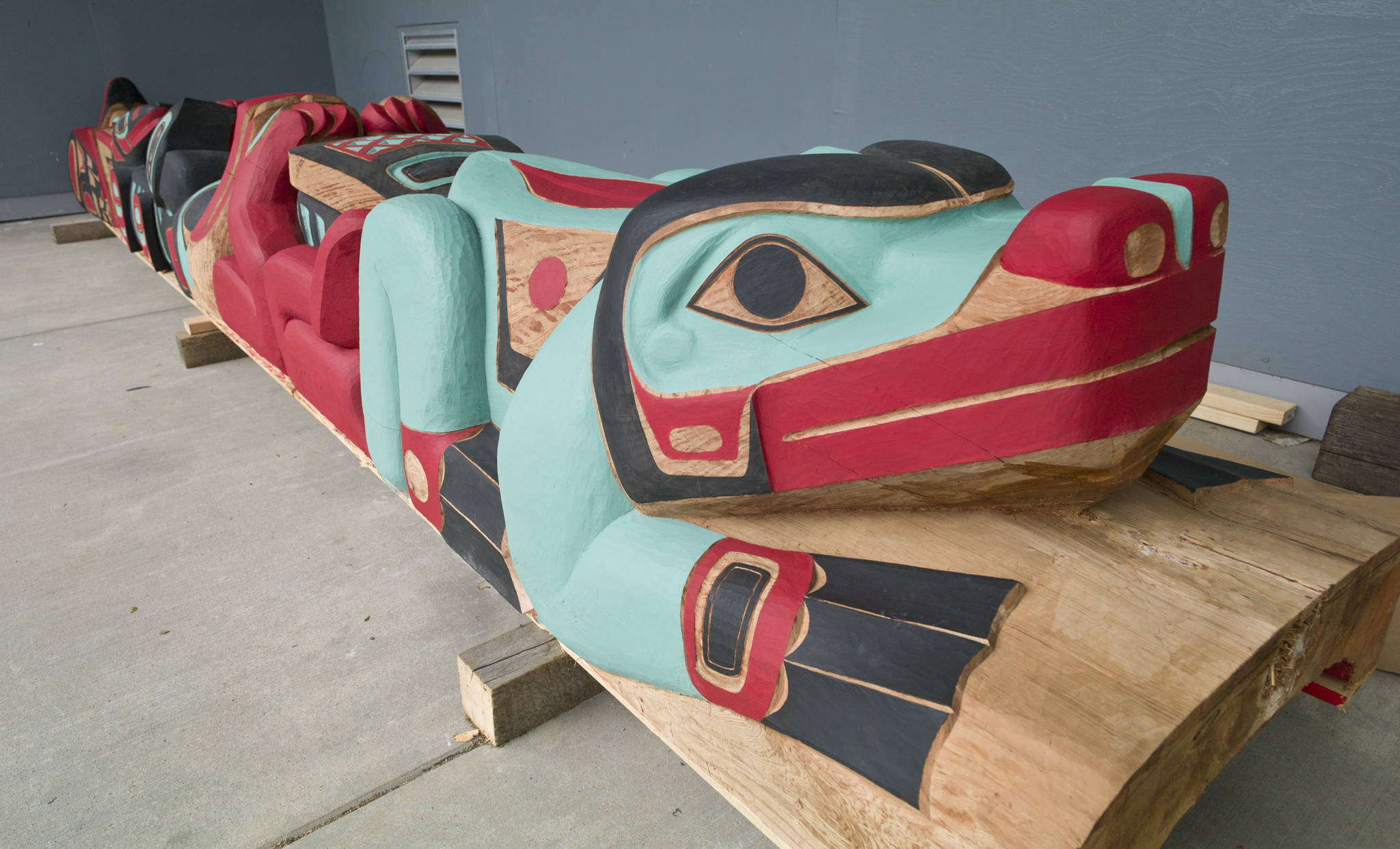 Reggie Peterson has carved two totem poles, this one is the raven pole, that will be presented at the Macaulay Salmon Hatchery on Saturday. (Michael Penn | Juneau Empire)