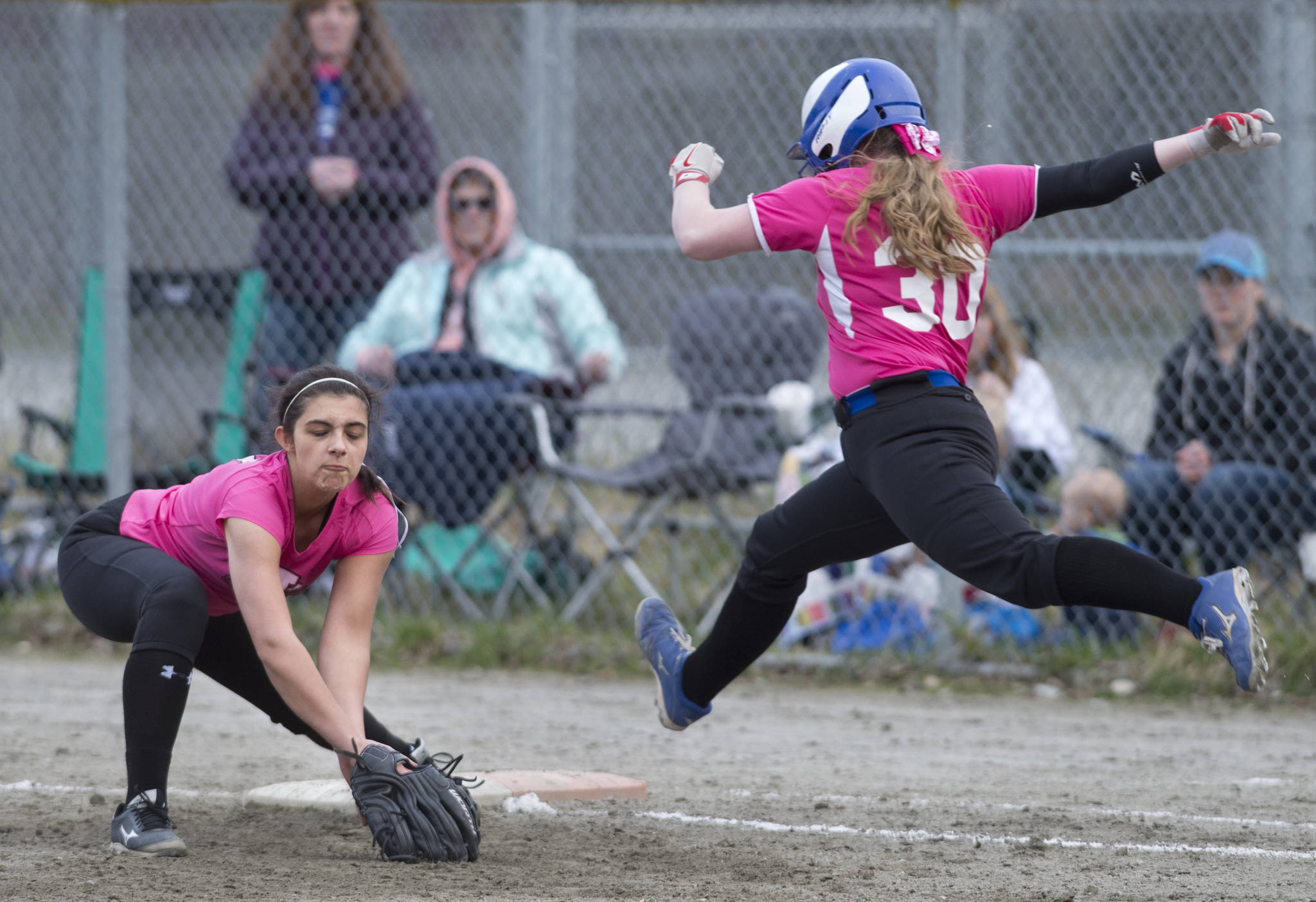 Thunder Mountain’s Rachel McCaulay makes a leap for first base as Juneau-Douglas’ Leah Spargo makes the catch for the out at Melvin Park on Friday, May 5, 2017. (Michael Penn | Juneau Empire)