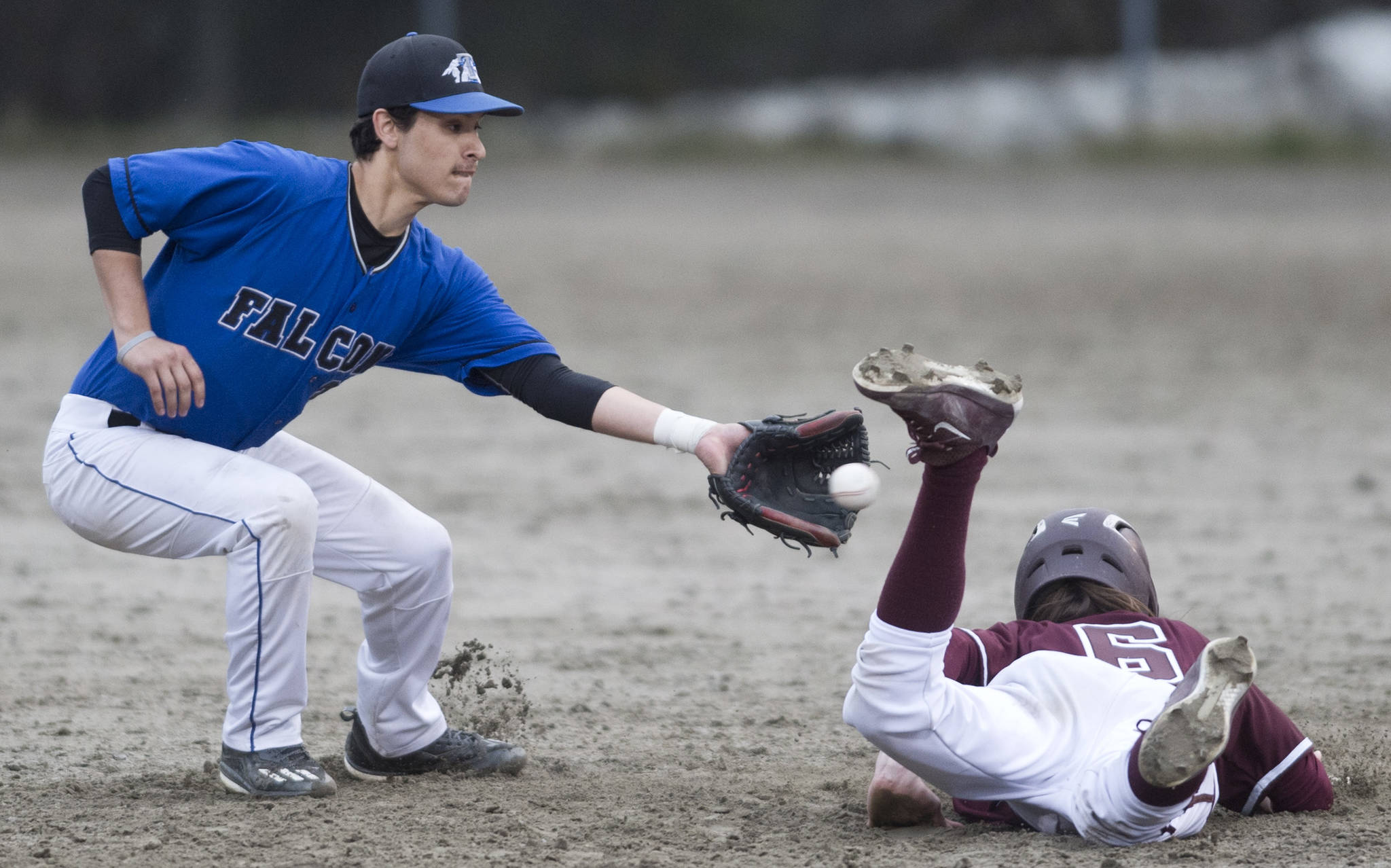 Ketchikan’s Liam Kiffer dives safely back to second base as Thunder Mountain’s Owen Mendoza receives the pick off throw in the third inning at Adair-Kennedy Memorial Park on Friday, May 5, 2017. (Michael Penn | Juneau Empire)
