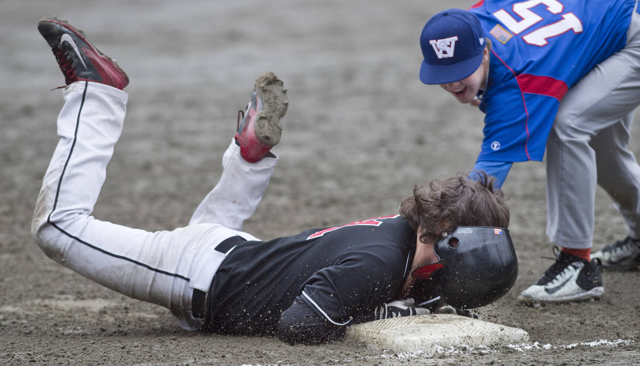Juneau-Douglas&rsquo; Niko Hebert slides safely into third base against Sitka&rsquo;s Bryce Kelly in the second game of a double-header at Adair-Kennedy Memorial Park on Saturday, May 13, 2017. (Michael Penn | Juneau Empire)
