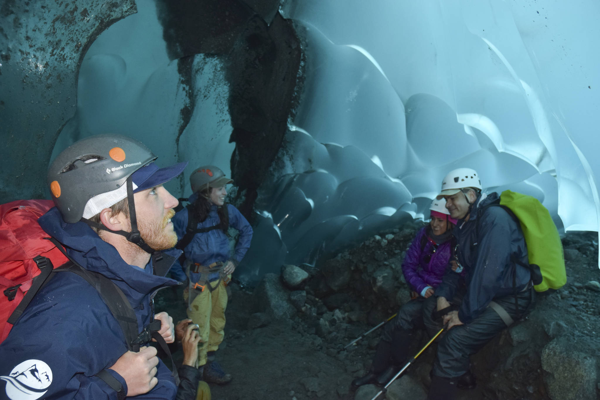 Above and Beyond Alaska tour guides Ben Hines, left, and Sarah Galvin, middle, talk with tourists Miguel Faur and Maria Isabel Ramos in the Mendenhall Glacier ice caves on Wednesday. (Kevin Gullufsen | Juneau Empire)