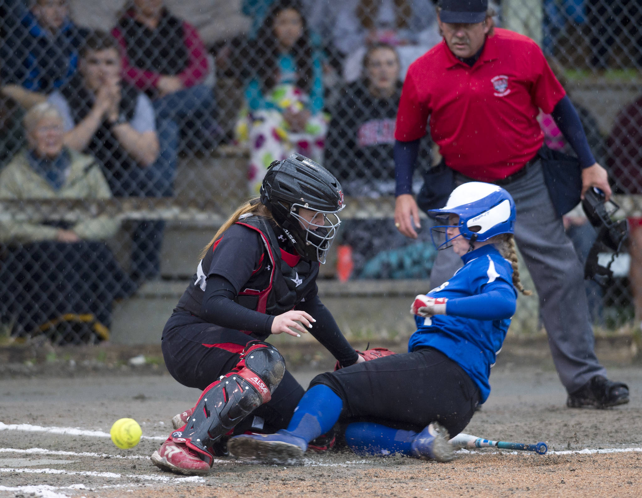 MICHAEL PENN | JUNEAU EMPIRE Thunder Mountain’s Rachel Macaulay, right, slides safely home as the ball gets away from Juneau-Douglas’ catcher Morgan Balovich during their game at Melvin Park on Friday.