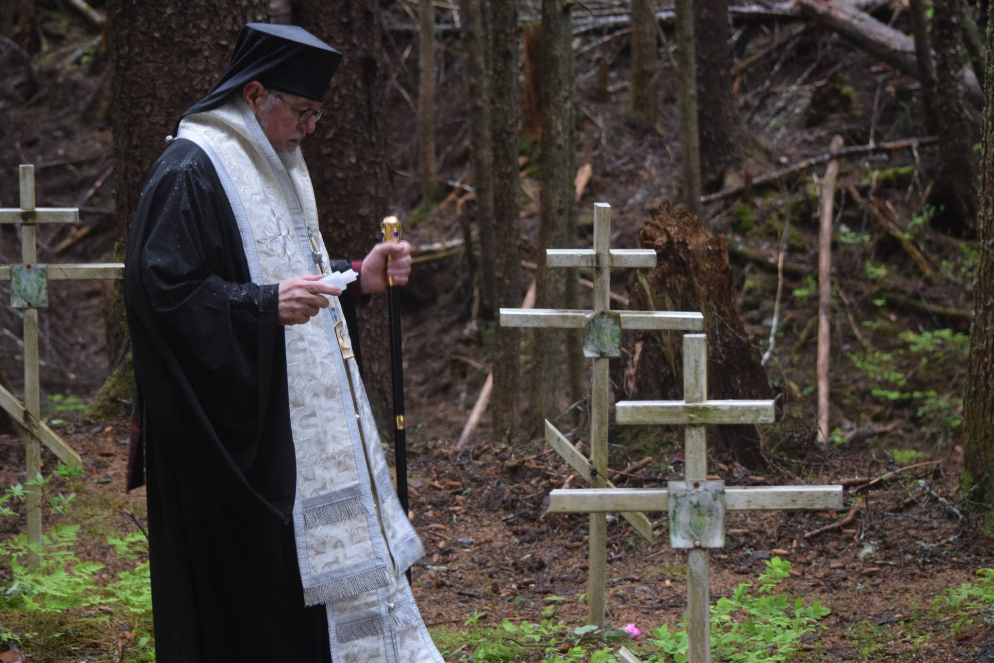 Bishop David (Mahaffey) blesses grave sites at the location of a WWII internment camp for Aleuts in Funter Bay, on Admiralty Island. (Kevin Gullufsen | Juneau Empire)