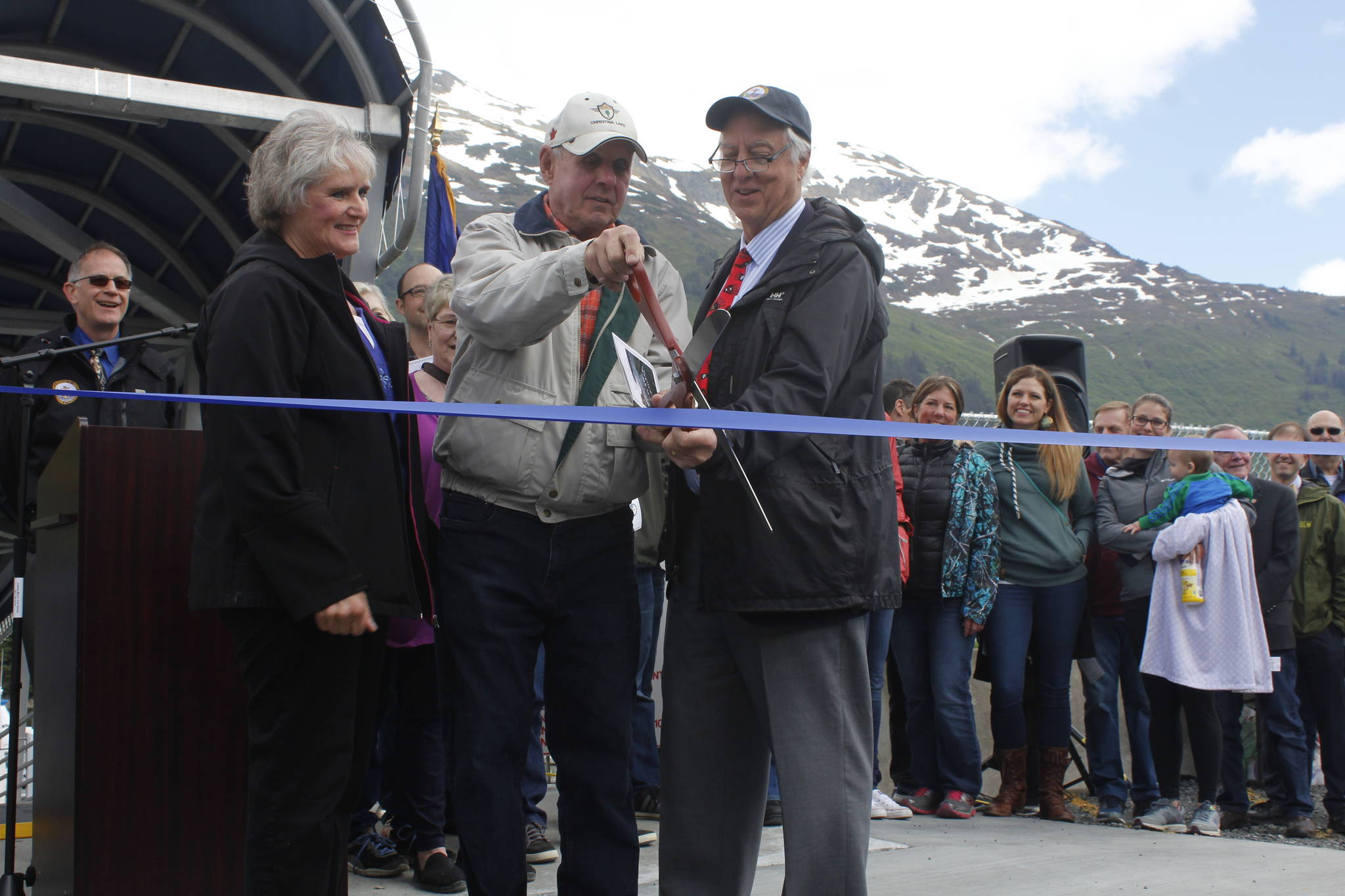 From left, Sharon Pusich Gill, Louie Pusich and Mayor Ken Koelsch lead the ribbon-cutting ceremony for the new Mike Pusich Douglas Harbor on Friday. The city completed renovations on the harbor this spring, which now carries the name of the former Douglas mayor who first advocated for the harbor. (Alex McCarthy | Juneau Empire)