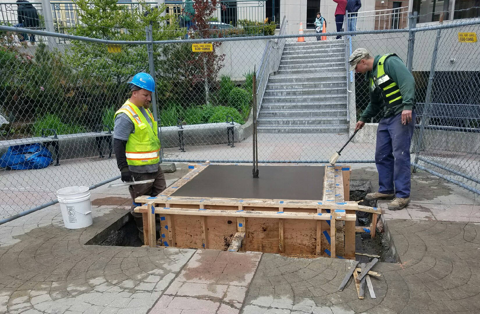 Kris Brown, foreman (left) and Wayne Coogan (right), employees of Coogan Construction, finish pouring the concrete pedestal for William H Seward statue. (Photo courtesy of Wayne Coogan)