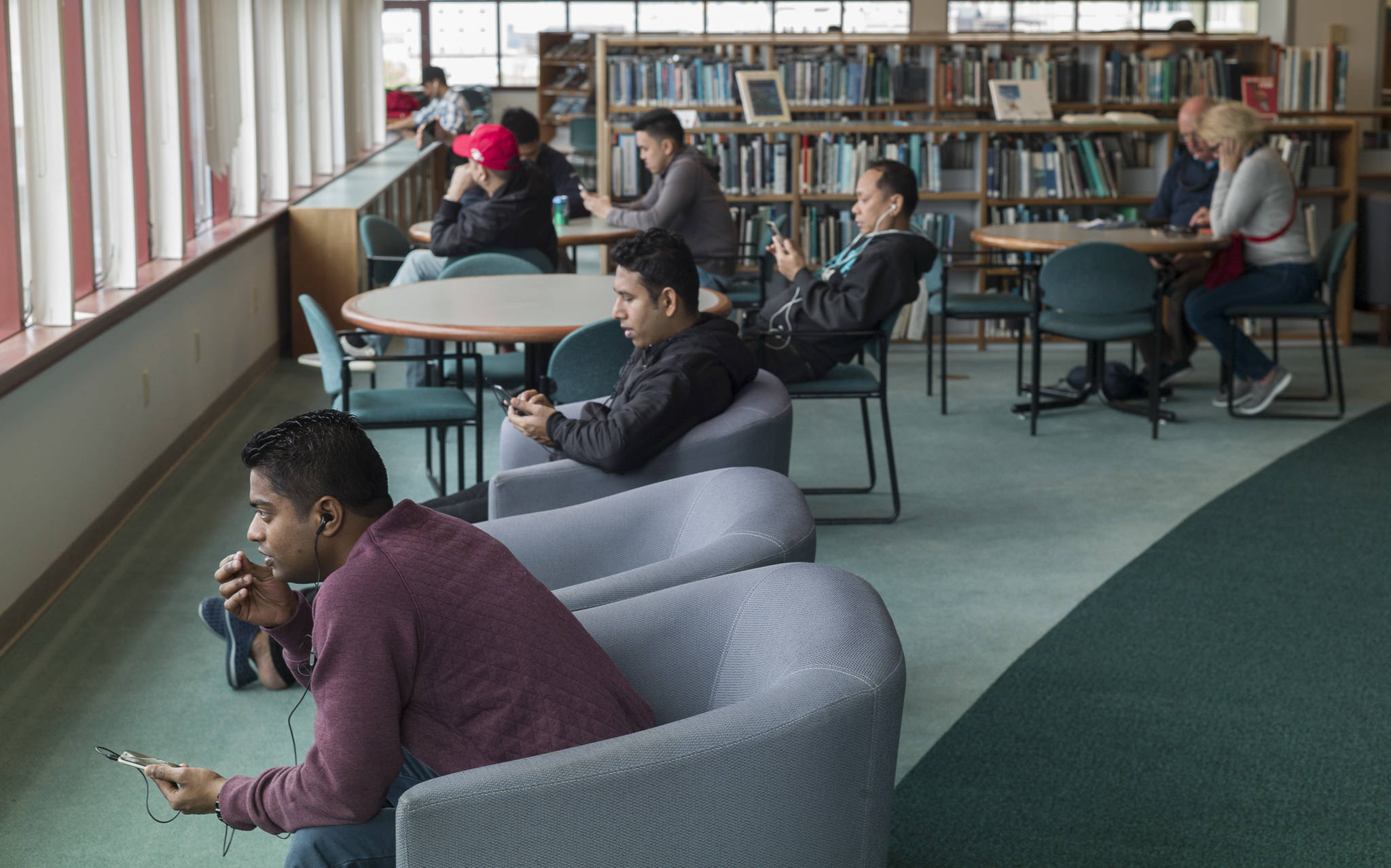 Visitors make use of the free internet connection at the Downtown Public Library on Tuesday, May 30, 2017. A city budget meeting on Tuesday is looking at possible cuts to libraries to help balance the budget. (Michael Penn | Juneau Empire)