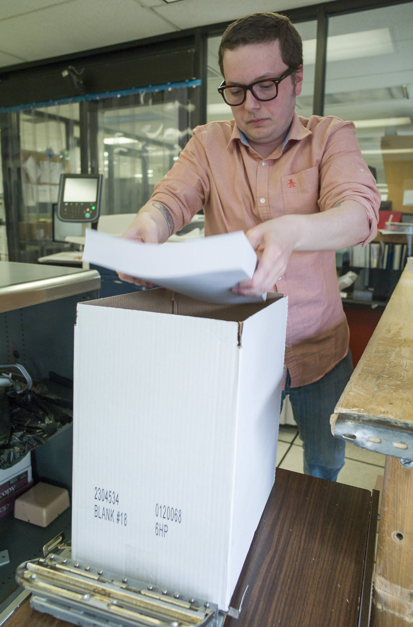 Will Muldoon, a data processing technician for the state of Alaska, boxes printed pink slip letters at a printing facility in the State Office Building on Tuesday, May 30, 2017. The letters will be sent to state employees on Thursday, June 1, if the legislature fails to pass a budget by then. (Michael Penn | Juneau Empire)