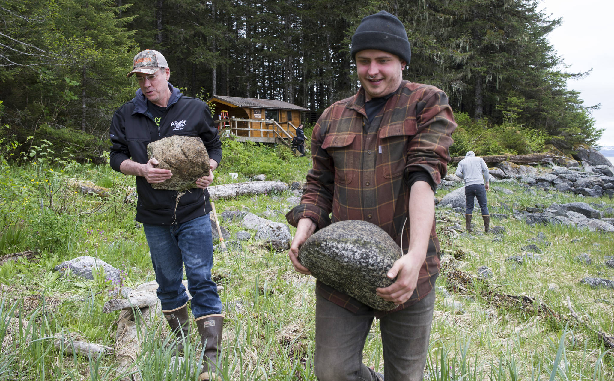 Andy Kline, communications director for the Alaskan Brewing Company, left, helps Trail Mix employee Mike Cotyk gather rocks for a path leading to the U.S. Forest Service’s Berners Bay Cabin on Thursday, May 25, 2017. (Michael Penn | Juneau Empire)
