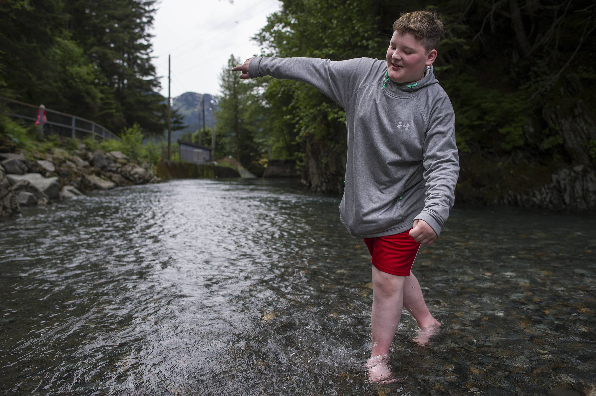Reilly Hayes, 12, tests out the water of Gold Creek at Cope Park on Friday, June 2, 2017. Hayes’ thoughts in a word, “Cold”! (Michael Penn | Juneau Empire)