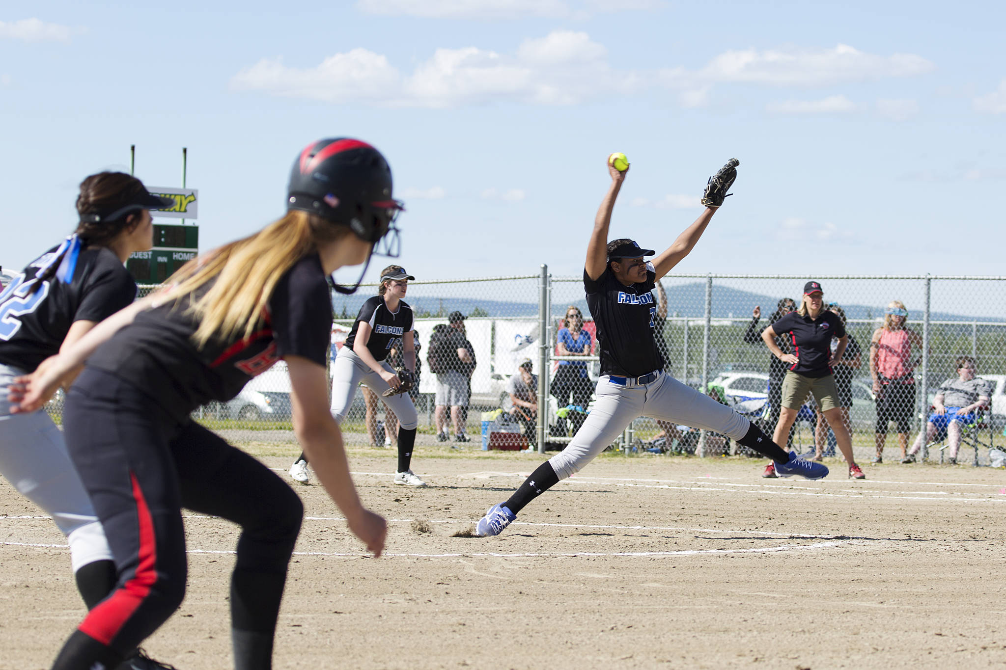 Kyra Jenkins Hayes winds up for the pitch while Juneau-Douglas High School&rsquo;s Elisa Fabrello waits attentively at third base during the ASAA Small Schools State Championship game, Saturday, June 3. (Sarah Manriquez | For the Juneau Empire)