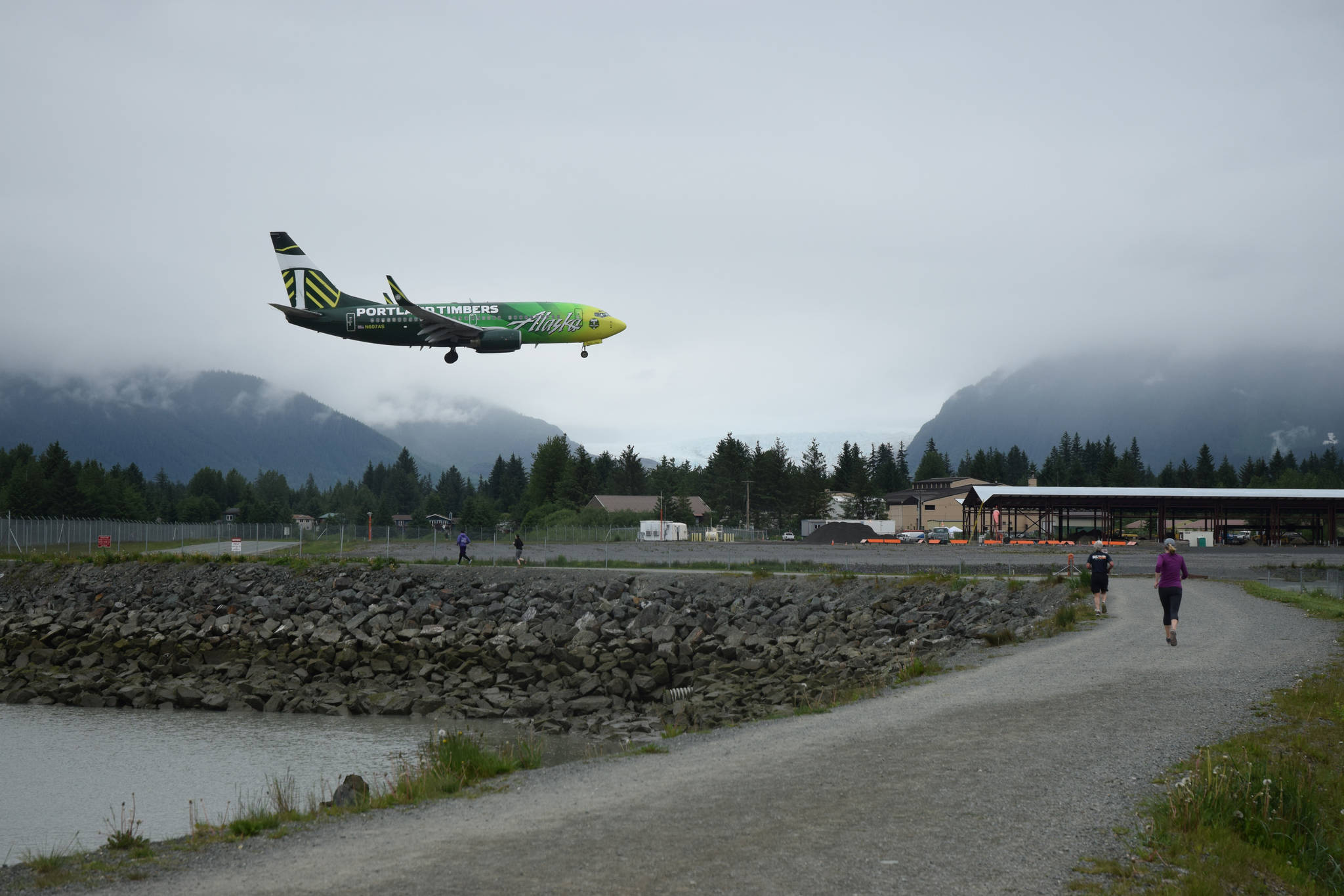 An Alaska Airlines jet prepares to land at the Juneau International Airport as runners compete in the Wild for Conservation 5K, Saturday, June 10. The race raised money for the Southeast Alaska Land Trust, a non-profit conservation group based in Juneau. (Nolin Ainsworth | Juneau Empire)