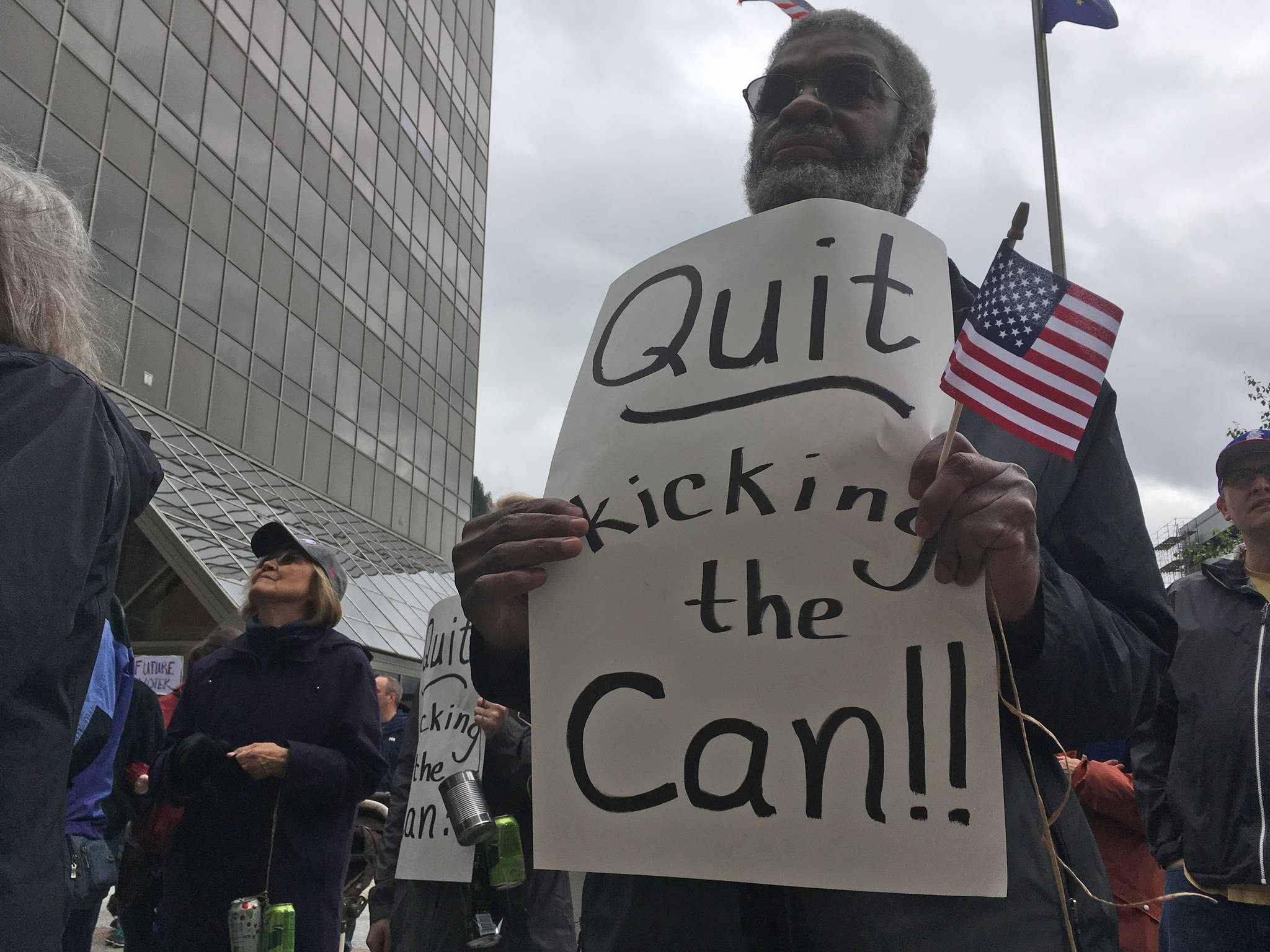 Retired union organizer Willie Anderson holds a sign during the Sunday, June 11, 2017 rally in front of the Alaska Capitol. (James Brooks | Juneau Empire)