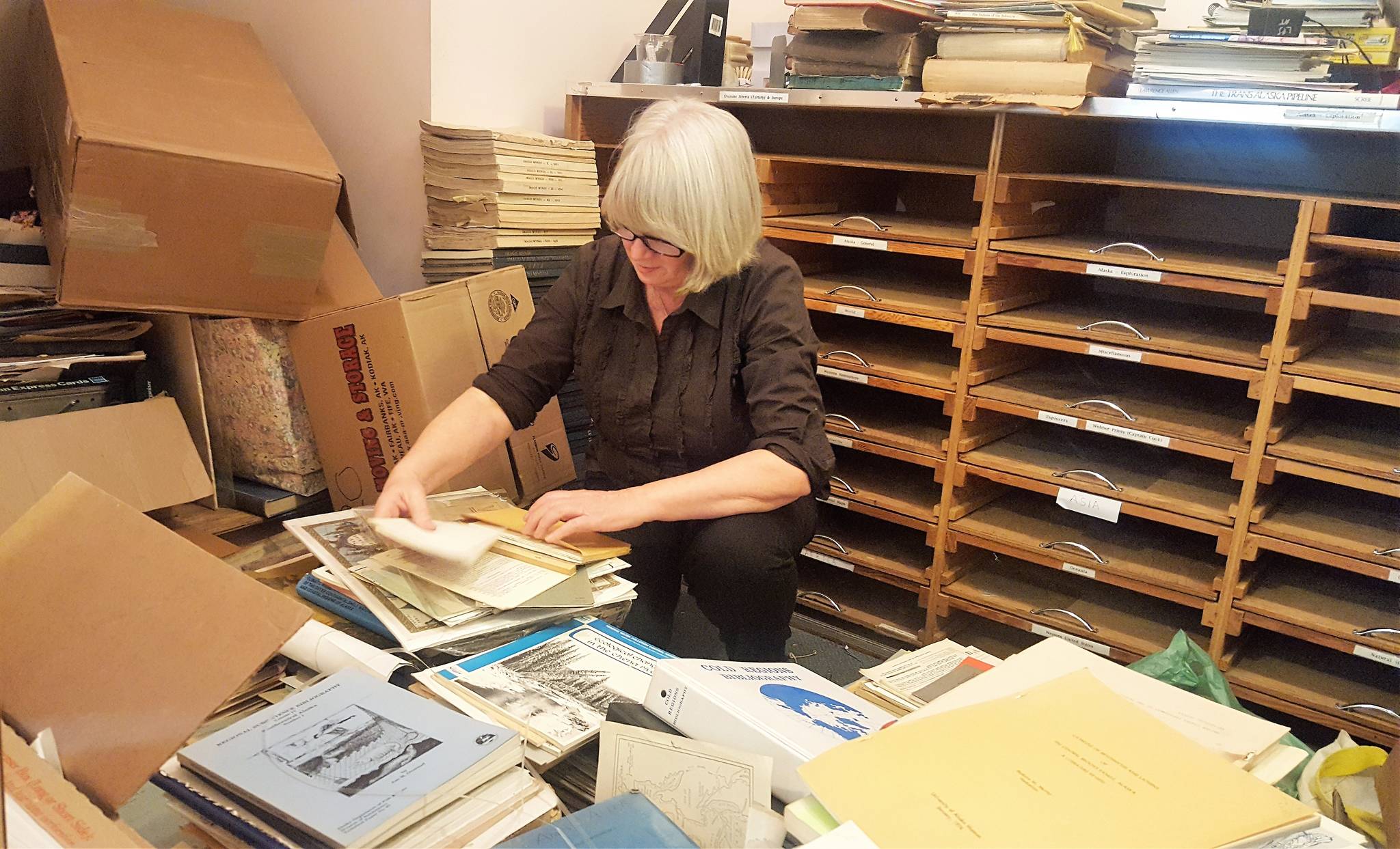 Patti David has spent 14 weeks sifting through the thousands of books, maps and ephemera in The Observatory bookstore as she helps the family dispose of the stock. (Liz Kellar | Juneau Empire)