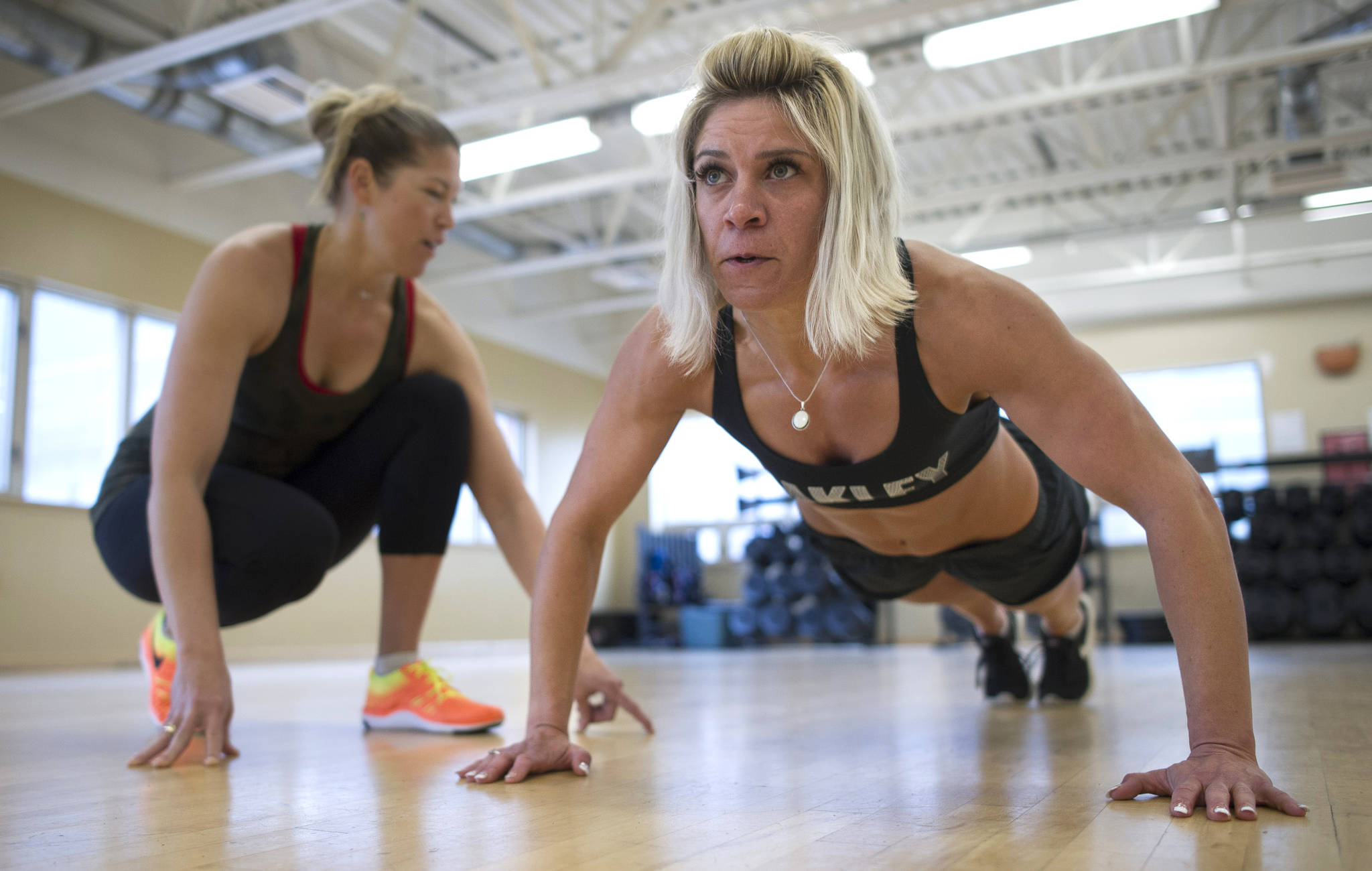Lacey Godkin works out with trainer Jamie Troxel at the downtown Alaska Club on Wednesday, June 21, 2017, before her trip to Anchorage to compete in her first figure contest. (Michael Penn | Juneau Empire)