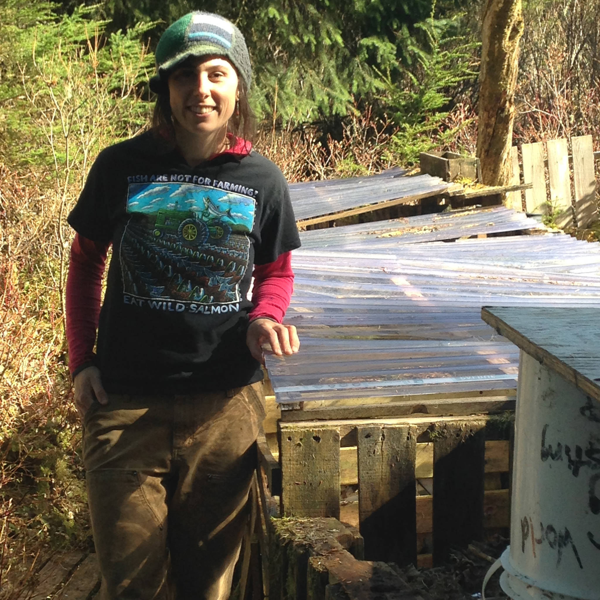 Lisa stands near the bins to show the clear plastic that covers the compost. (Corinne Conlon | For the Juneau Empire)