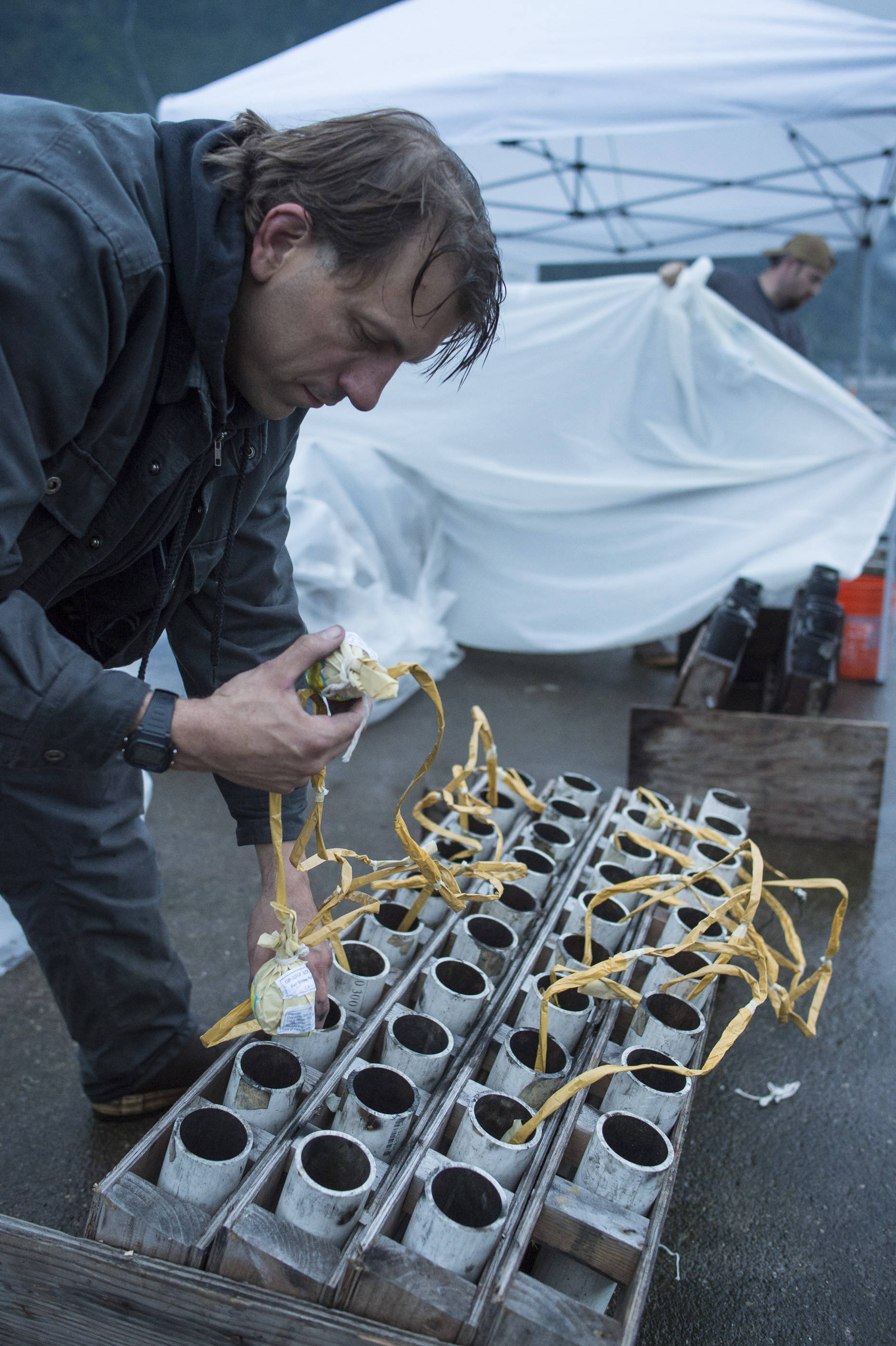 Volunteer Ian Dinneford loads two-and-a-half-inch bombs before the annual city-funded fireworks show in Juneau’s downtown harbor on Tuesday, July 3, 2017. (Michael Penn | Juneau Empire)