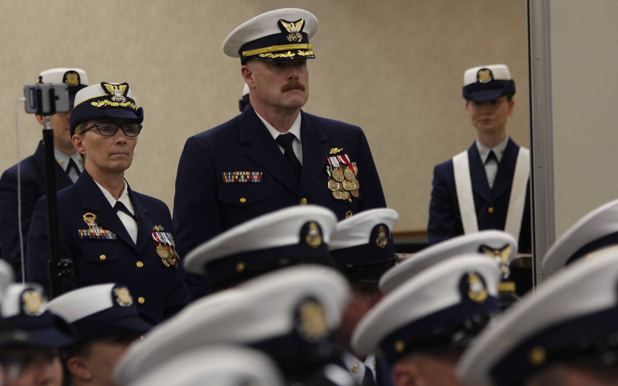 Capt. Shannan Greene (left) stands next to Capt. Phillip Thorne (center) prior to a change of command ceremony Friday. Greene transferred her command of Sector Juneau to Thorne. (Alex McCarthy | Juneau Empire)