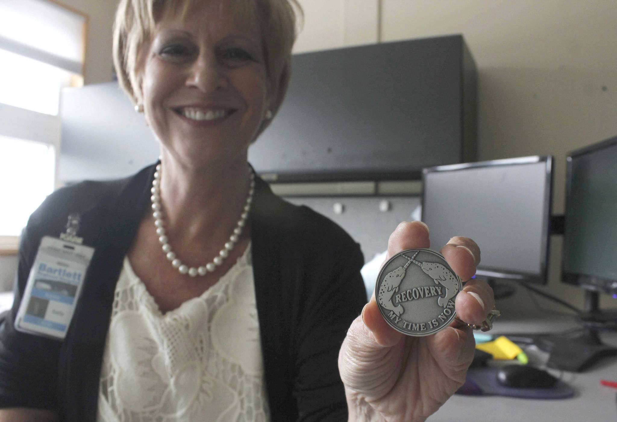 Sally Anne Schneider, departing her position as Chief Behavioral Health Officer at Bartlett Regional Hospital, holds a coin given to patients who complete a program at Rainforest Recovery Center. Schneider says the state of mental health and addiction treatment in Juneau is slowly improving and she’s hopeful for the future. (Alex McCarthy | Juneau Empire)