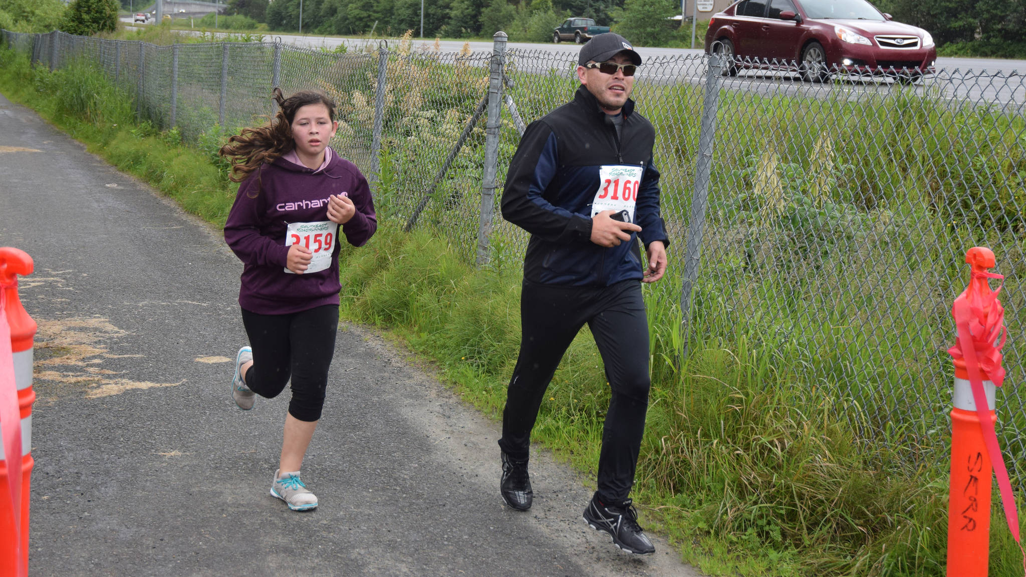 Ashlyn Lara, left, and Santiago Lara finish the McDowell Group Governor’s Cup 5K outside the Juneau Bone and Joint Center, Saturday, July 8, 2017. (Nolin Ainsworth | Juneau Empire)