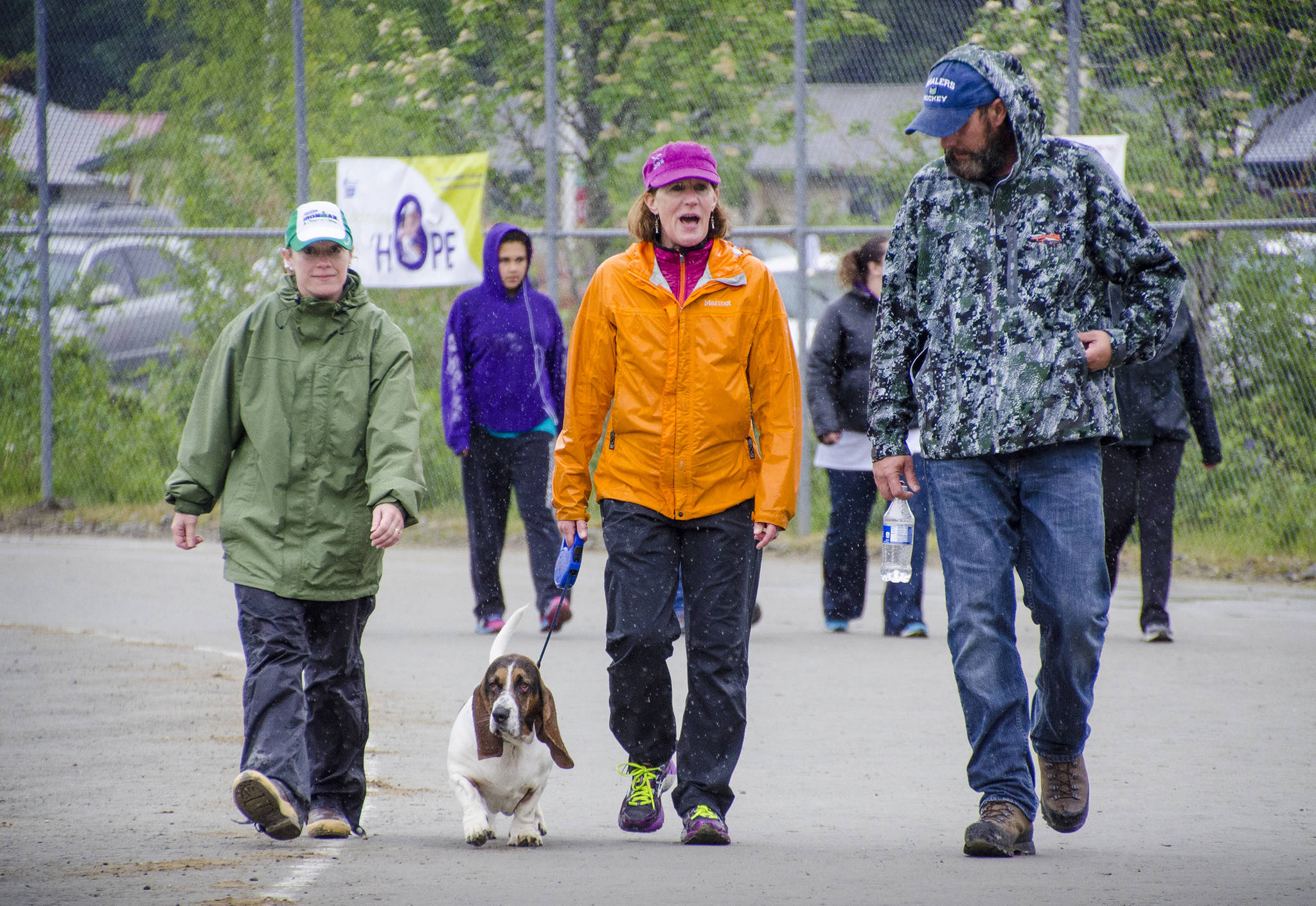 In this 2014 file photo, Kim Campbell, dog Frazier, Melanie White, and Bill Campbell walk laps during the Relay for Life at Riverbend Elementary School. (Marlena Sloss | Juneau Empire)