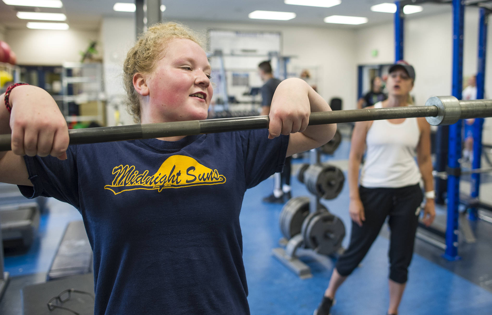 Mia Loree lifts weights under the guidance of Cori Metzger, Director of Sports Performance at Western Oregon University and host of the Juneau Football and Sports Performance Camp, at the Thunder Mountain High School on Tuesday, July 11, 2017. (Michael Penn | Juneau Empire)
