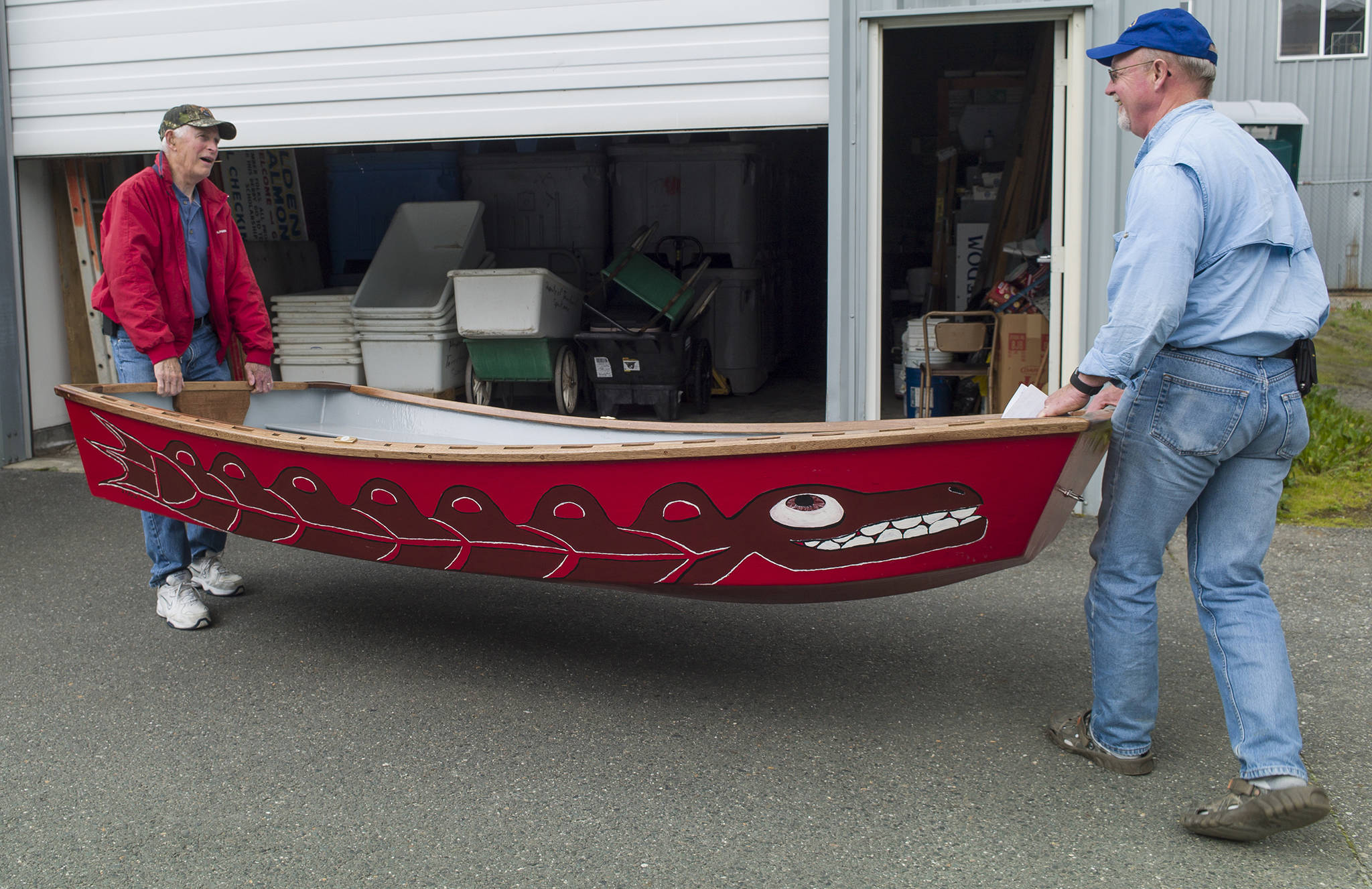 Ron Somerville, left, and Doug Larsen, of Territorial Sportsmen Inc., show on Monday, July 17, 2017, a 10-foot wood and fiberglass boat built and donated by Juneau-Douglas High School students. The boat will be a prize for the biggest fish caught by a youth, 16 years and younger, during next month&rsquo;s Golden North Salmon Derby. (Michael Penn | Juneau Empire)