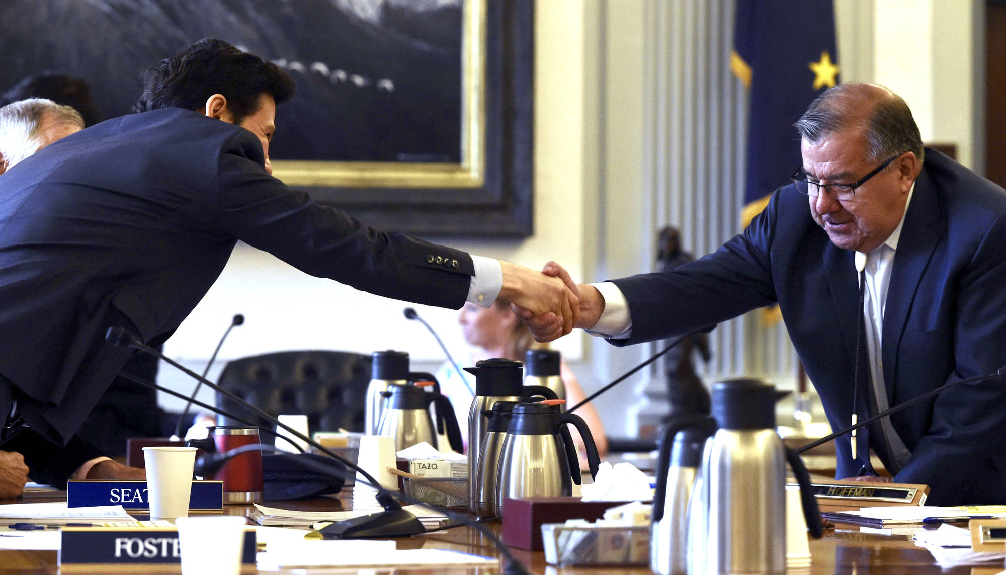 Rep. Neal Foster, D-Nome, left, shakes hands with Sen. Lyman Hoffman, D-Bethel, after an agreement is made on the capital budget in conference committee at the Capitol on Thursday, July 27, 2017. (Michael Penn | Juneau Empire)